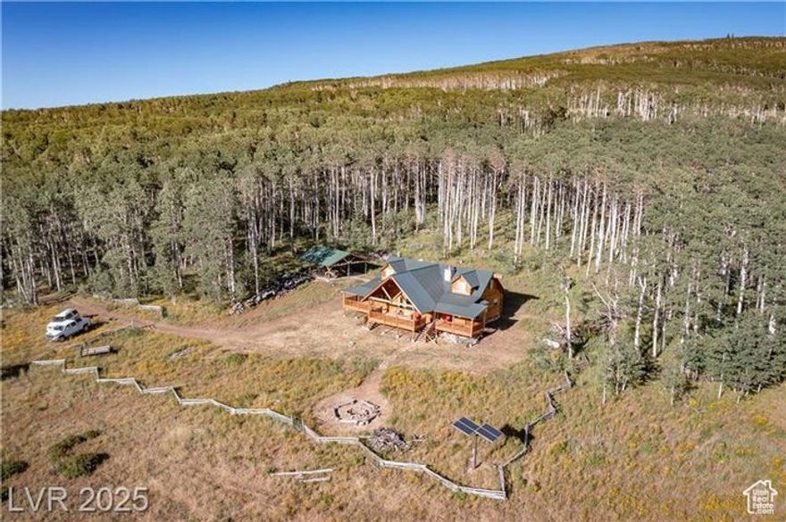 Perched at an awe-inspiring elevation of 9,150 feet on 40 secluded acres, this charming log-sided cabin is a hunter's paradise and wildlife lover's dream. Sip coffee on the porch as deer, elk, and wild turkey wander by. Inside, vaulted ceilings, a custom rock fireplace, and log furnishings create warm, rustic elegance. The main-floor primary suite offers comfort and privacy, while the loft features two cozy sleeping areas and a central family room. A  acre-foot of deeded spring water, pumped to a tank above, provides reliable mountain living. Gather at the wood-and-metal pavilion for sunset views and fireside stories. With ATV trails, star-filled skies, and nature at your doorstep, this Cedar Mountain retreat is the perfect escape.