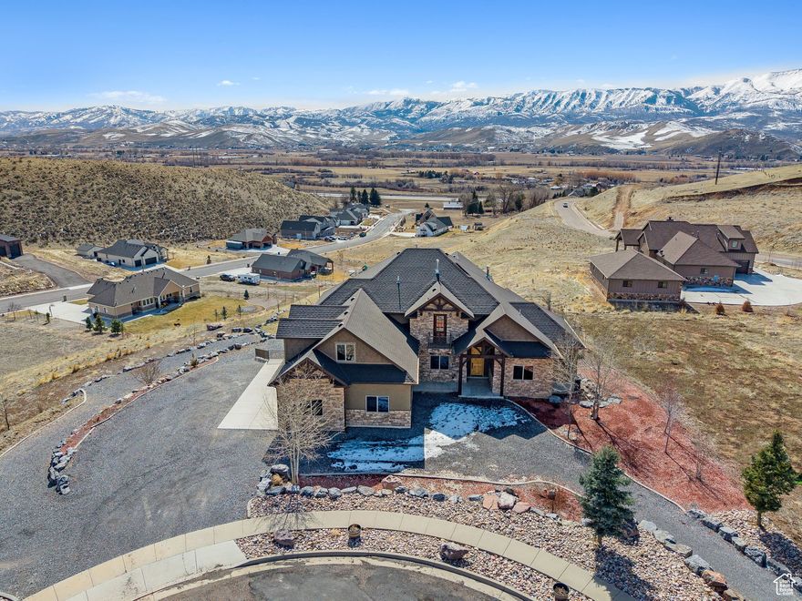 Nestled on the east bench of Morgan Valley, this custom-built estate offers privacy, luxury, and breathtaking panoramic views. Set on 1.25 acres among newly built luxury homes, it blends modern comfort with nature. A major remodel enhanced its elegance, featuring two master suites-one on the main level for convenience and another upstairs with a soaker tub, double-entry shower, sitting area, and gym. The open-concept design is perfect for entertaining, while the walk-out basement adds versatility with a second laundry, workshop, and ample storage. While outdoors, enjoy a private sports practice area and stunning valley and mountain views. Conveniently located between world-class ski resorts and top-rated schools, this home is a masterpiece of design and function.