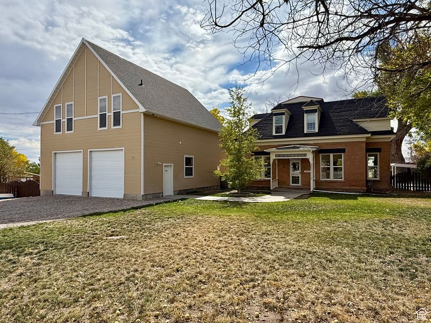 Historic Charm Meets Modern Comfort!  Step into the timeless character of this beautifully updated 1905 Vernal home sitting on a spacious lot with endless extras. This property blends old-world craftsmanship with thoughtful modern updates. Inside, enjoy a farmhouse kitchen featuring a farm sink, tile countertops and backsplash, stainless steel appliances, and a Wolf 6-burner gas cooktop-perfect for culinary enthusiasts. The home boasts original wood floors, bamboo flooring, a formal dining area, living room, den, full bath, and mudroom. Upstairs you'll find 3 bedrooms and a full bath, with a master suite enhanced by custom built-ins. The exterior shines with a fresh coat of paint, fenced backyard, garden spaces with 4 raised beds, apple and pear trees, fire pit, chicken coop, and a charming garden shed. For relaxation, there's even a hot tub outlet ready for your spa setup. Car lovers and hobbyists will appreciate the detached garage with heated floors from a boiler, half bath with utility sink, and a fully equipped 1280 SF ADU above the garage. This private apartment includes its own entrance, yard, parking, 1 bedroom, 1 bath, and appliances-ideal for guests or rental income. Adding to the property's uniqueness are two historical treasures: the original homestead structure with workbench and the old smithy complete with forge, connecting you to the property's rich past. Additional features include a well house with water right #45-5707. This is truly a one-of-a-kind opportunity to own a property that blends history, functionality, and charm-all while offering versatile living options.