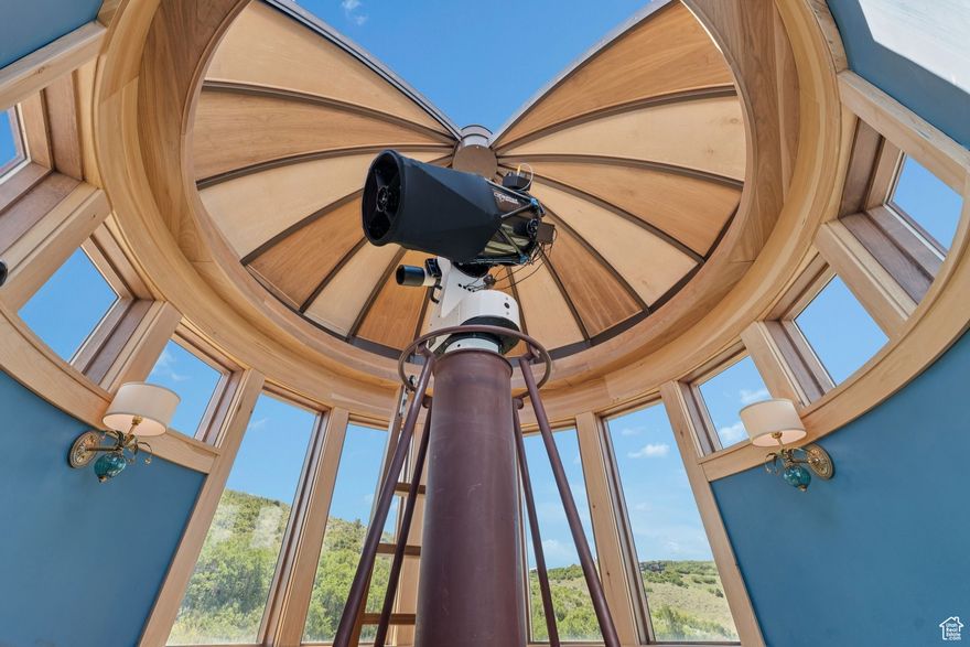 An Astronomer's Dream Home- A European Masterpiece with a Private Observatory. If you've ever dreamed of exploring the stars from your own home, this is the place. This extraordinary Victory Ranch residence blends old-world European artistry with the awe of a private observatory, complete with a telescope and retractable dome roof. With handcrafted details including a 1,000 sq ft spa, gourmet kitchen, turret library, and panoramic views, this home is both imaginative and masterfully executed. A true one-of-one. Perched on 4+ acres, this architectural masterpiece overlooks the renowned Rees Jones-designed golf course. Designed with intention, this Honka home features custom pine timber from Finland. The construction is natural, sustainable, and free from synthetic insulation. Throughout the home, custom Venetian lighting highlights the exquisite craftsmanship. The living room boasts soaring vaulted ceilings and expansive windows that frame breathtaking views. At its heart is a one-of-a-kind four-sided fireplace adorned with hand-painted designs. The elegant kitchen is a chef's dream, with custom walnut, maple, and glass cabinetry, a walnut countertop with iridescent blue inlay. Adding to its uniqueness is a custom Pechka and pizza oven, hand-built on-site. The extraordinary library is housed in a stone turret with curved walnut & maple doors and inlaid custom floors. Above it, a private observatory serves as the home's crown jewel, equipped with a telescope & a retractable dome roof. The home features 5 luxurious suites, each with unique scenic views. Outdoor living is just as impressive, with a covered patio featuring a built-in grill and multiple balconies. A two-car garage and custom dog wash station complete the home. Victory Ranch is a gated community on over 6,250 pristine acres with 4 miles of private Upper Provo River access, offering a lifestyle of unmatched adventure and serenity.