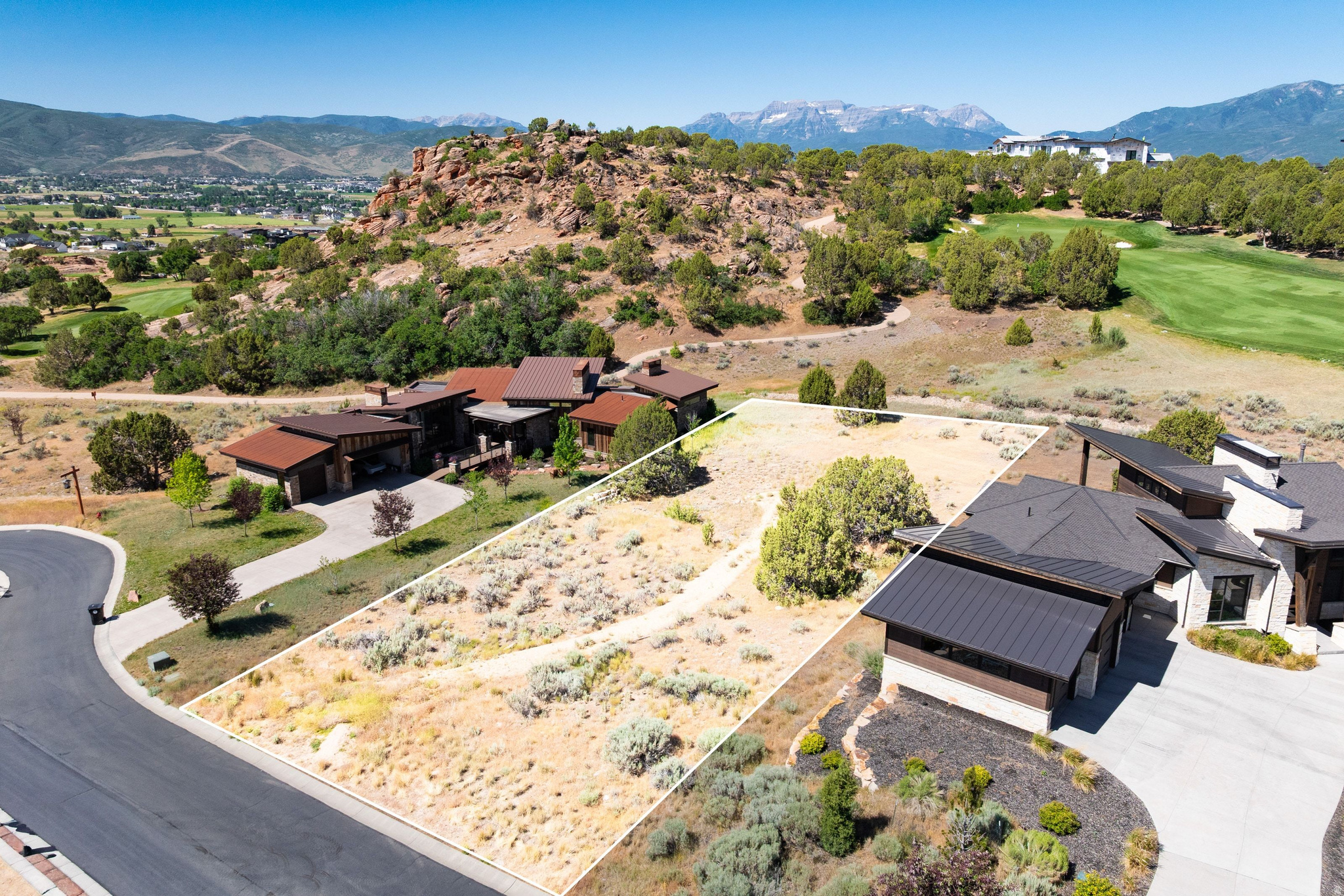 Generous land parcel featuring natural desert landscaping, mature shrubs, and direct road frontage