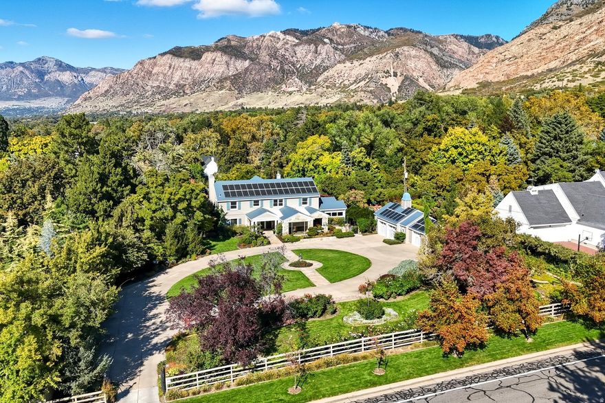 A rare opportunity to own an extraordinary property located high on the east bench in one of Ogden's most coveted neighborhoods. This estate-like residence is distinguished by its exceptional grounds-lush landscaping, exquisite rose and flower gardens, and towering mature trees-all thoughtfully designed for both relaxation and entertaining. Set on a full acre, the property offers refined outdoor living at its finest. A gracefully terraced backyard is centered with a dramatic waterfall, koi pond and stone fire pit. The flagstone patio off of the kitchen invites unforgettable seasonal gatherings with its built-in grill, stone pizza oven, and striking outdoor fireplace-all framed by a majestic mountain backdrop. Built in 1937 and tastefully updated over the years, its historic character and charm remain. The layout and living spaces are elegant and sophisticated, yet warm and inviting. Oversized windows flood the interior with natural light, blending the beauty of the surrounding gardens and views seamlessly with the interior. You are welcomed by an impressive foyer with marble tile floors, intricately carved columns, and a sweeping staircase. The grand living room centers around a commanding fireplace and opens through French doors to a year-round sunroom. A serene den with a fireplace overlooks the changing seasons showcased in the backyard, and a spacious formal dining room provides the perfect setting for holiday gatherings and special occasions. The central hub of the house is the chef's kitchen and adjoining family room featuring marble and granite countertops, a center island, high-end built-in stainless-steel appliances, custom cabinetry, a wine bar, and a beverage fridge. Throughout the home, hardwood flooring, custom millwork, coffered ceilings, picture rail molding, and detailed carvings elevate the craftsmanship and charm. Upstairs, a generous primary suite offers a spa-like bathroom with a heated soaking tub, steam shower, elegant vanities with ornate fixtures and leads to an adjoining bedroom that creates a separate dressing area. Additional bedrooms, a full bathroom, and a potential laundry area complete the upper level. The lower level includes a family room, fifth bedroom, bathroom, sauna, and storage areas. A detached three-bay garage with additional storage room completes this exceptional offering. The property is steps from mountain trails and just minutes from historic downtown Ogden. Steeped in history and timeless beauty, 1528 Maule Drive awaits its next steward to define its future.