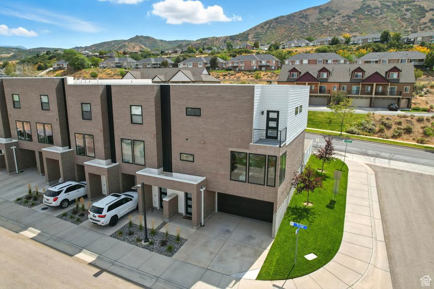 Discover the perfect balance of modern design, comfort, and adventure in this stunning 4-bedroom, 3.5-bath end-unit townhome. Perched to capture sweeping views of the Salt Lake Valley, this home offers not only beautiful spaces but also an unbeatable lifestyle, just minutes from world-class mountain biking trails, scenic hiking paths, shopping, dining, and quick freeway access. Step inside through the welcoming entry or attached 2-car garage to find a private bedroom with its own bathroom-ideal for guests, in-laws, or a quiet home office. Walk up the stairs to the heart of the home features a bright, open-concept kitchen and spacious living area that flows to a private deck. It's the perfect place to entertain friends after a day of hitting the trails or to relax with sunset views over the valley. On the top floor your private retreat awaits in the primary suite, complete with a walk-in closet, en-suite bath, and its own deck for morning coffee with mountain air. Two additional bedrooms, a full bathroom, and a conveniently located laundry room complete this level. Outside, the fenced backyard offers space for kids to play, pets to roam, or summer BBQs with neighbors. With both everyday convenience and outdoor adventure just steps away, this townhome is truly one of a kind.