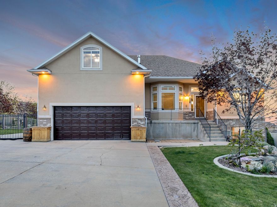 Set along a mountainside with breathtaking 360 views of the mountains, lake, and valley, this property offers a rare combination of space and panoramic beauty. From sunrise to sunset, the ever changing landscape becomes part of everyday living, creating a setting that feels open, grounded, and expansive. The outdoor spaces are designed to be fully experienced, with a large fenced in yard, garden boxes ready for planting, and multiple areas for gathering, relaxing, and entertaining. Whether hosting under the open sky or enjoying a quiet evening by the gas fire pit, the setting invites connection and ease. The deck is equipped with a built in gas line, making outdoor cooking and entertaining seamless. Inside, the home features an open layout with vaulted ceilings that enhance the sense of space and natural light throughout. Allowing those gorgeous Utah sunsets to seep in, as you wind down for the evening. The primary suite offers a comfortable retreat with his and hers closets, and generous room for large furniture. A 3 car garage provides ample parking and storage, while a separate workshop building adds flexibility for projects, hobbies, or additional workspace. The walk out basement brings in abundant natural light and includes a fully equipped mother in law apartment, offering flexibility for guests, extended living, or potential rental income. Additional features include a furnace with a built in humidifier for added comfort and efficiency. With its combination of sweeping views, versatile living spaces, and thoughtfully designed indoor and outdoor areas, this property delivers a setting that feels both elevated and intentional. Call now for a private showing! All information herein is deemed reliable but is not guaranteed. Buyer is responsible to verify all listing information, including square feet and acreage, to buyer's own satisfaction.