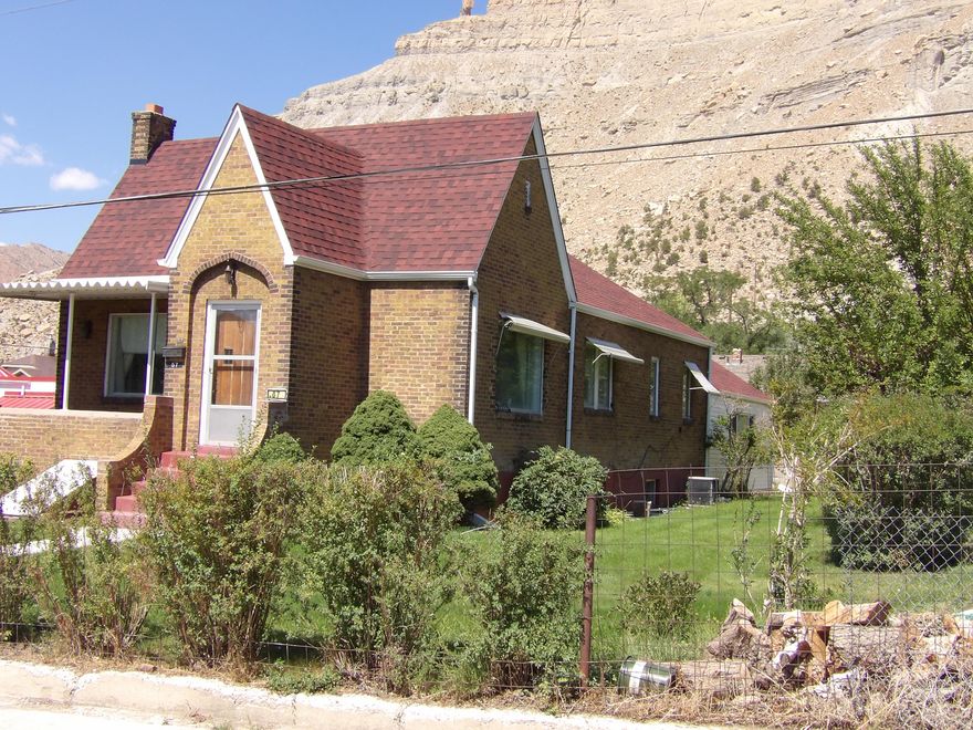 HUGE PRICE REDUCTION ON THIS SPACIOUS 4 BEDROOM BRICK HOME IN HISTORIC HELPER! Schedule a tour to see this Tudor-style home with over 3,600 square feet. Also, includes 3.5 water shares through the Spring Glen Canal Company. This property offers the perfect blend of privacy and conveniently located a short distance from downtown Helper. The main level of this charming home features two bedrooms and a full bathroom along with built-In storage in the hallway. Additional storage can be found in each bedroom closet, ensuring ample space for all your belongings. Entertain guests in the formal living room, which provides plenty of space for family and friends. The formal dining room is large enough for family gatherings. The eat-in kitchen is a cozy spot for casual meals, equipped with a large walk-in pantry and newer appliances, making it a practical and inviting space for cooking and dining. The expansive family room addition features real hardwood flooring and a stunning rock fireplace with a woodstove insert, ideal for those cooler evenings. With large picture windows in the living and dining rooms, the main level is bathed in natural light, creating a warm and inviting atmosphere. The basement offers 2 additional bedrooms and a 3/4 bathroom with a corner shower with natural light. Relax on the patio and soak in the peaceful surroundings of Helper while appreciating the nearby beautiful red rock mountains. Enjoy the view of the famous balanced rock sitting on top of the mountain nearby. The property is home to an apricot tree, apple tree and walnut tree, adding to its charm. A manual sprinkler system helps maintain the lush greenery surrounding the home. The detached two-car garage provides plenty of storage space, ideal for vehicles and outdoor equipment. The home features several updates, including a newer roof and siding on the family room. Tax ID: 1A-1082-0000 is included in the sale. Conveniently located near ATV trails, the Helper River walkway and a vibrant arts community. Perfect home for those who love outdoor adventures and cultural events in Helper throughout the year. Square footage figures are provided as a courtesy estimate only and were obtained from the Carbon County Tax Records. Buyers are advised to obtain an independent measurement for accuracy.