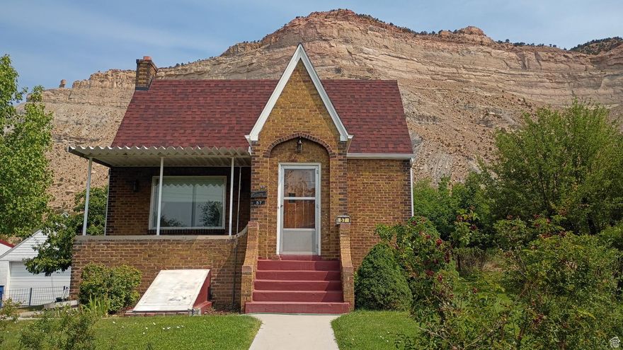 WOW! Listing includes a 4-bedrooms, 1 3/4 bathrooms, garage and two city lots with alley access in historic Helper, Utah. Consider taking a tour of this spacious brick Tudor-style home with over 3,600 square feet. This property offers the perfect blend of privacy and conveniently located a short distance from downtown Helper. The main level of this charming home features two bedrooms and a full bathroom along with built-In storage in the hallway. Additional storage can be found in each bedroom closet, ensuring ample space for all your belongings. Entertain guests in the formal living room, which provides plenty of space for family and friends. Adjacent to this is the formal dining room, perfect for enjoying dinner with loved ones. The eat-in kitchen is a cozy spot for casual meals, equipped with a large walk-in pantry and newer appliances, making it a practical and inviting space for cooking and dining. The expansive family room addition features real hardwood flooring and a stunning rock fireplace with a woodstove insert, ideal for those cooler evenings. With big picture windows in the living and dining rooms, the main level is bathed in natural light, creating a warm and inviting atmosphere. The basement offers 2 additional bedrooms and a 3/4 bathroom with a corner shower with natural light. Relax on the patio and soak in the peaceful surroundings of Helper while appreciating the nearby beautiful rock mountains and views of balance rock. The property is home to an apricot tree, apple tree, and walnut tree, adding to its charm. A manual sprinkler system helps maintain the lush greenery. The detached two-car garage provides plenty of storage space, ideal for vehicles and outdoor equipment. The home features several updates, including a newer roof and siding on the family room. Tax ID: 1A-1082-0000 is included in the sale. Water shares are included with the sale. Conveniently located near ATV trails, the Helper River walkway and a vibrant arts community, this home is perfect for those who love outdoor adventures and cultural experiences. Square footage figures are provided as a courtesy estimate only and were obtained from the Carbon County Tax Records. Buyers are advised to obtain an independent measurement for accuracy.