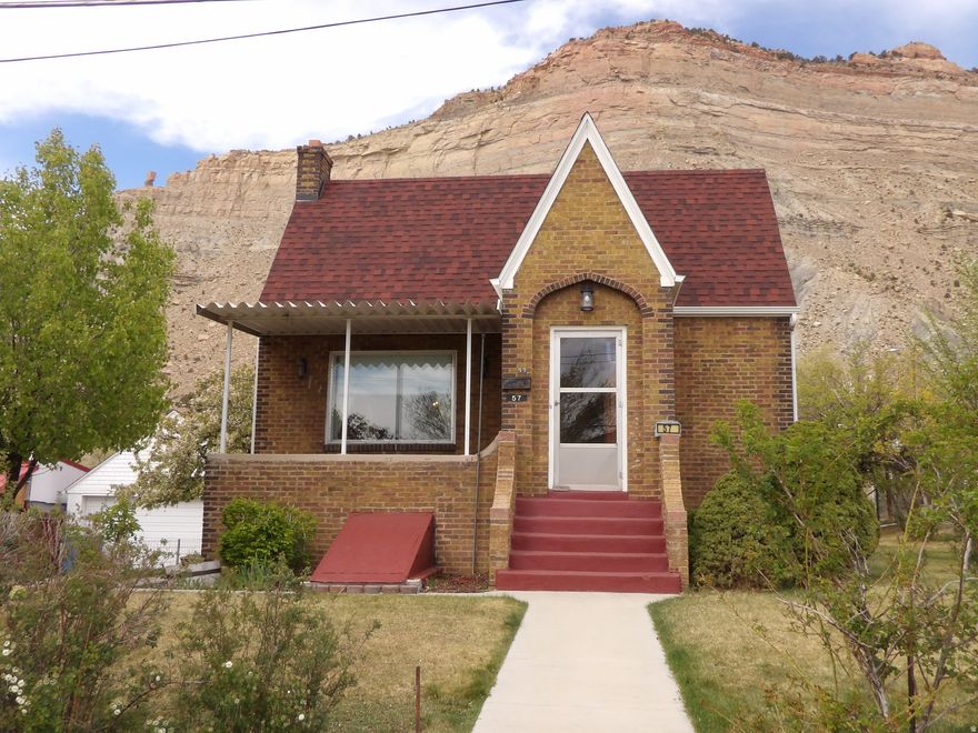 Investment Opportunity! Huge price reduction on this unique home in historic Helper where the movie Salt and Honey was filmed recently. Charming Tudor-style home offers over 3,600 square feet of comfortable living space, along with 3.5 valuable water shares through the Spring Glen Canal Company. Listing includes a large lot to the East that could be used as a garden spot along with alley access to both properties. The main level features two bedrooms, a full bathroom and built-in hallway storage, with additional closet space in each bedroom. A spacious formal living room and large dining room make entertaining easy, while the cozy eat-in kitchen includes newer appliances and a generous walk-in pantry. The standout family room addition boasts real hardwood flooring and a striking rock fireplace with a woodstove insert-perfect for cozy evenings. Large picture windows in the living and dining areas offer natural light, creating a warm and inviting atmosphere. Downstairs, the basement offers two additional bedrooms and a  bathroom with a corner shower and natural light. Outside, enjoy peaceful surroundings from the patio, with scenic views of Helper's iconic red rock landscape. The property also features: Mature apricot, apple, and walnut trees, a manual sprinkler system for easy yard maintenance, a detached two-car garage with ample storage. Updates include a newer roof and siding on the family room. A new gas meter was recently installed by the gas company. Located near ATV trails, the Helper River walkway and a thriving local arts scene. This home is ideal for those who appreciate both outdoor adventure and cultural charm. Tax ID: 1A-1082-0000 included with the listing. Square footage figures are provided as a courtesy estimate only and were obtained from the Carbon County Tax Records. Buyers are advised to obtain an independent measurement for accuracy.