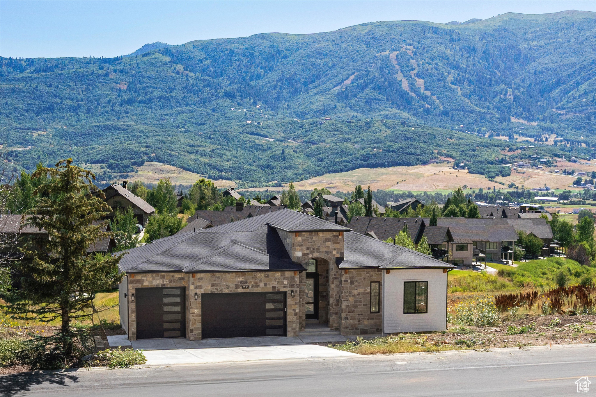Discover unparalleled luxury and the most impressive views in the Ogden valley with this custom-built Ranch home in Eden, Utah. This one-of-a-kind property boasts commanding views of the Wasatch Mountains, Ben Lomond Peak, Mount Ogden Peak, the Nordic Valley Ski Resort, and Snowbasin ski resort from the moment you walk through the front door. With 14-foot ceilings on the main level and 12-foot ceilings in the massive walk out basement, this open layout and views make this home an extremely unique and impressive property. This home sets a new benchmark for features that every homeowner would ever want or need. Living in a breathtaking mountain setting you will enjoy features such as massive bedrooms with impressive mountain views, a private study or flex room, a huge open kitchen and great room with views, views and more views! The huge, extra deep garage with a Wake boat bay, 9x9 door and 30 feet deep is a rare find. As you step inside, you are greeted by engineered highly durable and waterproof flooring that sweeps through most of the residence. The chef's kitchen is a culinary masterpiece, outfitted with a huge walk-in pantry and premium GE Caf appliances, including a 48" refrigerator, gas cooktop, double ovens and a drawer microwave. This space extends out onto an incredible covered outdoor living/entertaining area complete with an outdoor fireplace. The master suite is a haven of luxury, featuring a designer bathroom, an expansive walk-in closet, private access to the laundry and a private balcony that presents serene views-ideal for unwinding in privacy and comfort. The lower-level impresses with a massive entertainment area complete with more views, a wet bar, two bedrooms, an impressive bath, laundry, cold storage, extra storage, a living room with a separate entrance and an amazing soundproof theater room. This entire space offers great flexibility for extended stay guests or family. The walkout basement area also features a huge covered patio, ready and wired for a future hot tub. This property offers an array of additional luxurious features too numerous to list here, making it a truly exceptional home for those seeking luxury and exclusivity in one of Utah's most desirable locations. This home sits in a recreational paradise, offering direct access to Ogden Valley's extensive trail network, the Wolf Creek Resort golf course, water sports at Pineview Reservoir, and world-class skiing at Snow Basin, Powder Mountain and Nordic Valley. Square footage figures are provided as a courtesy estimate only and were obtained from building plans. Buyer is advised to obtain an independent measurement.