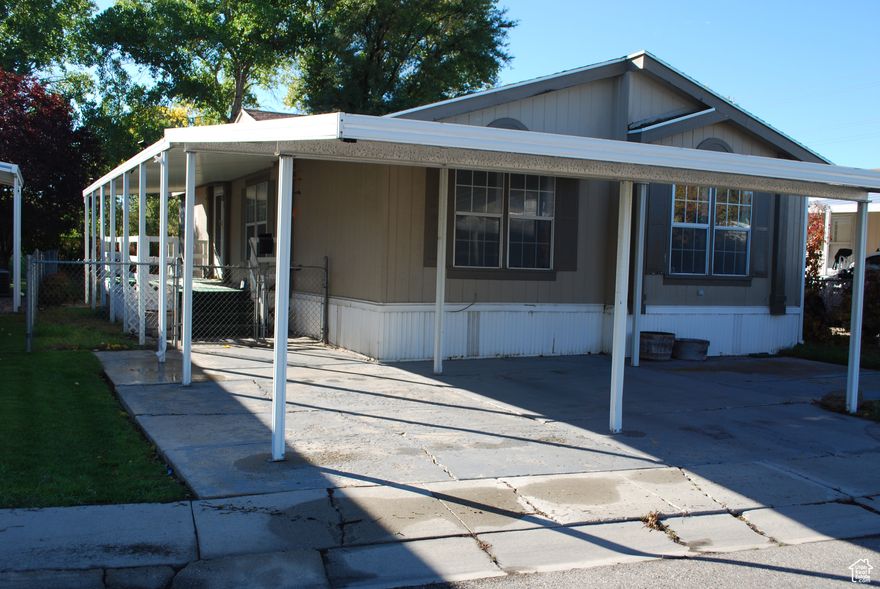 This double-wide home is unique in the fact that the walls are actually upgraded to sheetrock. It also has other upgrades like hardwood floors & custom cabinets.  The HVAC system is newer.  The water heater is newer.  Carpet is new.  Fresh paint. Washer/ gas Dryer are included. It has the convenience of a gas range/oven. The home sits on an oversized lot with no back neighbors and trees behind the lot to give it that perfect sense of privacy.  The covered parking and side patio are seamlessly connected to allow easy access to the home during inclement weather. Covered back porch.