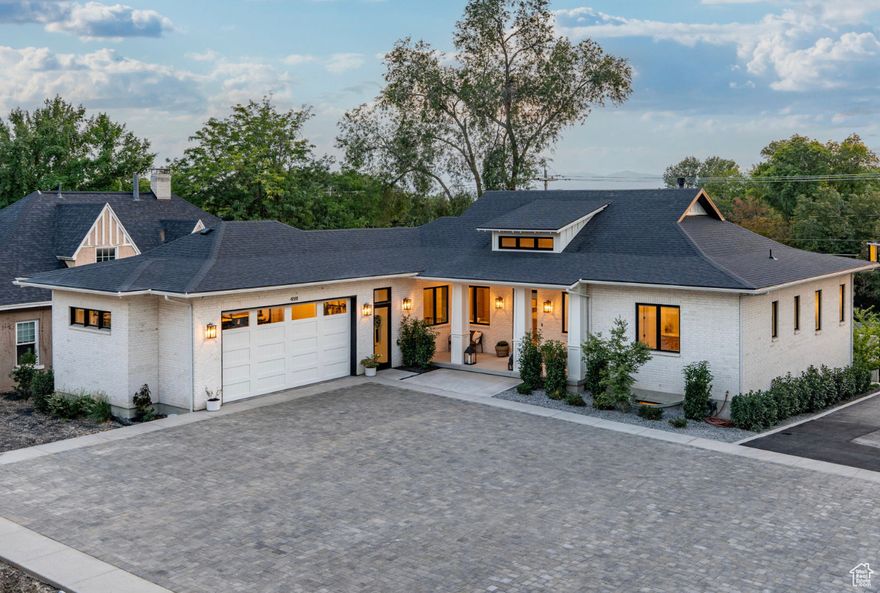 Discover this stunning all-brick custom home, ideally located within walking distance to Holladay Village. Completed in mid-2024, it blends distinctive architecture with modern design, offering a sophisticated urban feel and premium construction throughout. Inside, soaring vaulted ceilings, expansive windows, and a sunlit dining room set the tone for open, elegant living. High-end finishes include rift white oak, integrated Sonos sound, automated shades, and professional-grade Fulgor-Milano appliances. Designer lighting from Arhaus enhances the home's refined palette, while Brizo faucets, a steam shower, refrigerated bottle-filler, nugget ice-maker, and softened water elevate everyday living. Energy-efficient features-such as blown-in insulation, hybrid water heater, EV charging, and a waterwise yard-ensure comfort with low utility costs. The bright lower level opens to a beautifully landscaped, private sanctuary with fireplace, bike parking, and a designated space for a future hot tub. This home offers thoughtful design in every detail, both inside and out. Truly, there's nothing like a new, well-crafted custom build in this coveted Holladay location. Square footage figures are provided as a courtesy estimate only and were obtained from building plans. Buyer is advised to obtain an independent measurement.