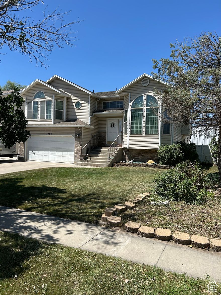 This is one of the larger and nicer three-level homes in this Cloverdell subdivision. Short commute--15 minute drive to Salt Lake City. The three upper-level bedrooms have walk-in closets. There is a large master-suite with separate tub and shower and enclosed toilet. A fifth room on the lower level can be used as a bedroom/den/craft-room (has a blower vent). The on-wall high-end loudspeakers in the downstairs living/home theater room and the master bedroom are included with the home. The TVs are excluded. Garage has 240V AC power installed so you can plug in power tools or your RV. Home also has a power transfer switch that can be hooked to a generator to power the furnace, fridge, one light and one electrical outlet if the main power goes out. Backyard needs a lawn or garden. RV space fits up to 31 ft.   Square footage figures are provided as a courtesy estimate only and were obtained from tax records.  Buyer is advised to obtain an independent measurement.