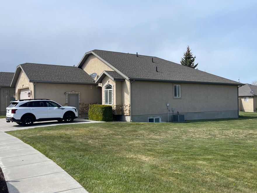 Spacious Bear Lake Retreat in The Cottages | 2054 S. Cottage Lane, Garden City, UT Discover one of the most generously sized homes in The Cottages at Bear Lake - a beautifully finished 6-bedroom, 3-bathroom rambler offering nearly 3,000 square feet of comfortable living just a short walk from the stunning turquoise waters of Bear Lake. From the moment you arrive, the stone and stucco exterior and covered deck set the tone for a home that blends mountain charm with thoughtful upgrades. Step inside to find hardwood, tile, and newer carpet throughout the main level, where a large master suite awaits - complete with a private bath featuring a separate shower and garden tub, an elevated finish that stands apart from the standard Cottages build. Granite countertops, a cozy gas log fireplace insert, and an open, functional layout make this home equally suited to quiet weekends and larger family gatherings. Downstairs, the fully finished basement delivers exceptional versatility with four additional bedrooms, a spacious open family room, and a three-quarter bath - plenty of room for extended family, guests, or a bunkhouse-style setup that sleeps a crowd in comfort. The extra-wide, extra-long 2-car garage provides ample space for vehicles, lake toys, and gear storage. Outside, enjoy a covered deck and open patio perfect for morning coffee or evening barbecues, with overflow parking right next door and paved roads throughout the community. The HOA covers snow removal and water for just $100/month, making year-round ownership genuinely low-maintenance. The Cottages is one of Bear Lake's most sought-after communities - close to the water, well-maintained, and refreshingly residential in character. The 30-day minimum rental policy keeps the neighborhood peaceful, making this the ideal personal retreat, family legacy property, or long-term vacation home for buyers who want Bear Lake without the noise of a nightly rental corridor. This is Bear Lake living done right - spacious, upgraded, and move-in ready.