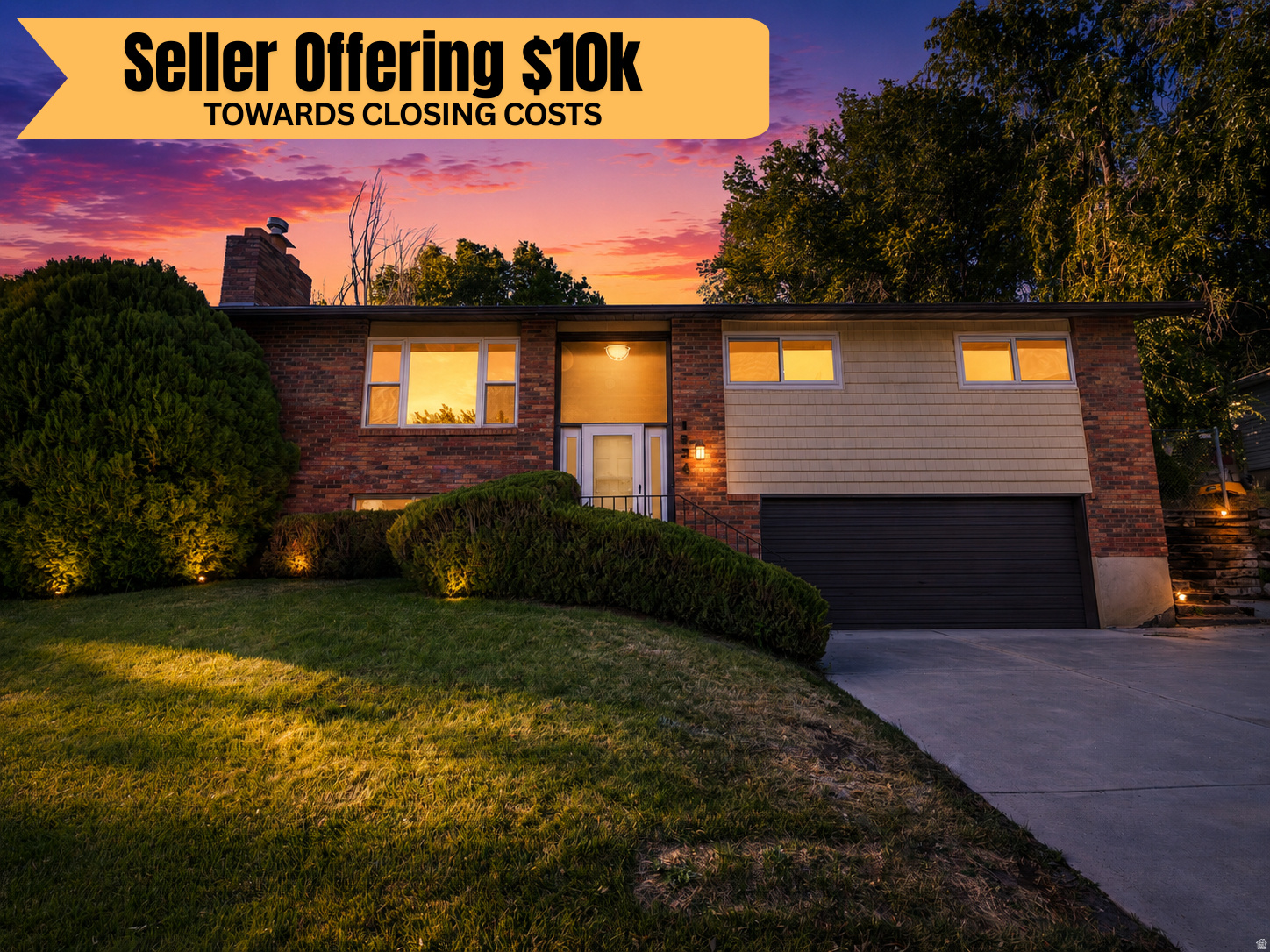 Brick and siding exterior with a dark garage door, illuminated entry, and exterior lighting