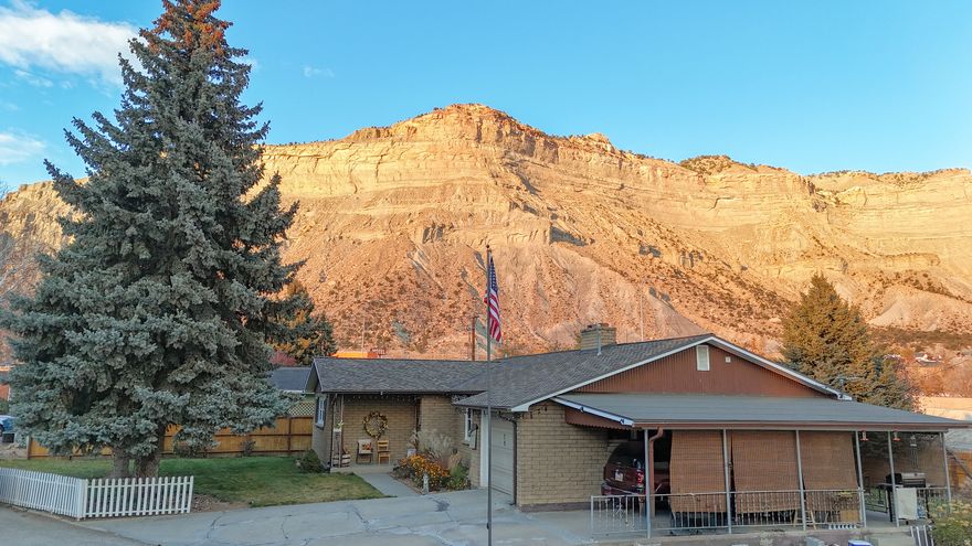 Homes with this kind of setting and character do not come along often. From the moment you arrive, you can feel the history and pride in this charming brick residence, set against the dramatic backdrop of Balanced Rock and the cliffs north of Helper. The landscaping frames the home beautifully, giving it a welcoming, established presence that only grows more appealing as you explore further.  Step inside and you are greeted by a warm, comfortable living room centered around a classic fireplace, the kind of space that has likely hosted decades of conversations, celebrations, and quiet evenings. The flow into the formal dining area makes the home ideal for gatherings, large or small. Thoughtful updates have already been taken care of, including a roof replacement and vinyl windows on the main floor.  Downstairs, the basement offers exceptional storage and flexibility. With plumbing and both gas and electric dryer hookups already in place, the space could easily support a second kitchen or hobby area.  Outside, the property continues to impress. You'll find a one-car attached garage, a one-car carport, and an additional detached garage, giving you ample room for vehicles, tools, and projects. Secondary water is provided through the Bryner-Hansen ditch for added convenience.  Even better, this sale includes a second parcel (Tax ID 1A-0334-0000), adding .21 acre that features a workshop and shed, plus another workshop in the basement. Whether you need storage, workspace, or room to expand, this property has options.  Priced below a recent appraised value and offering so much potential, this home is one you will want to see quickly. Homes with this combination of charm, views, and versatility are hard to find. Square footage figures are provided as a courtesy estimate only.  Buyer is advised to obtain an independent measurement.