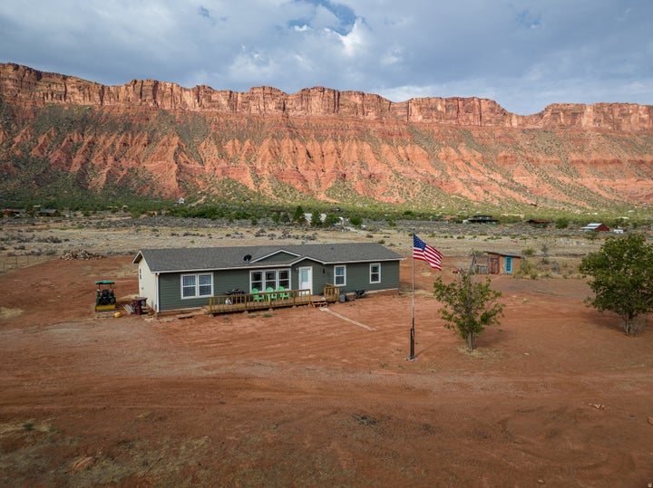 Single-story dwelling with dark green siding and white trim