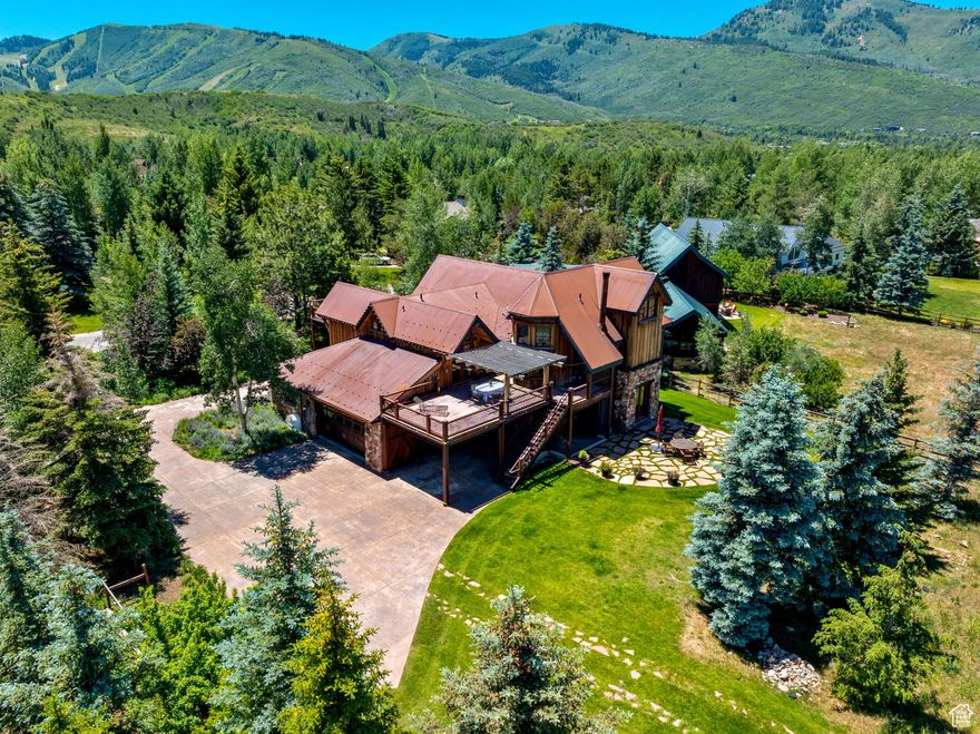 Welcome to 1396 Moray Court, a custom 5,077 sq. ft. estate home with a one-acre lot in the coveted Holiday Ranchettes equestrian subdivision. This is perhaps the premier street in the neighborhood-a quiet cul-de-sac with quick access to Park City, ski resorts, and trail systems. Featuring four bedrooms, five bathrooms, two offices, dual living rooms, and a semi-formal dining area, the home functions as a primary residence or an alpine escape. The home underwent a remodel and expansion in 2007 and has seen upgrades in the years since.    Thoughtful design elements like the wet bar's ice maker, walk-in kitchen pantry, oversized mud/laundry room, and enormous primary bedroom closet make for a comfortable existence in this warm abode. All bedrooms have ensuite bathrooms and walk-in closets. The primary suite is the crown jewel of the home, with its fireplace, oversized sitting area, large bathroom, private staircase to offices and storage, and outdoor access.   The materials of the property are stunning, featuring Wolf Creek Moss Rock, reclaimed barn wood, and Corten steel roofing. The home incorporates steel spans for the front porte-cochere, above which sits a private outdoor entertainment deck. In the rear, a similar deck offers seating and a private hot tub alcove off the primary suite's door. Below the rear deck, 10' clearance provides parking space for a small RV or van. In the rear half of the property, a gorgeous open pasture and flexible entitlements offer potential to build a large out-building or barn, with potential office, and entertainment space.    The Park Meadows lifestyle is second to none. The lot is bordered on the rear by a private equestrian bridle path for the use by Holiday Ranchette owners. 1396 Moray Court embodies the quintessential Park City lifestyle. With its spacious interior, premium features, and prime location, it presents a unique opportunity for those seeking an exceptional home in one of Utah's most sought-after communities.