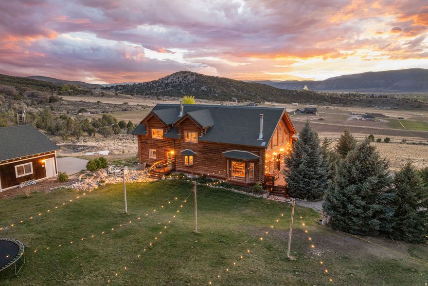 Elevated on 10 private acres just east of the iconic Manti Temple; this exceptional 4,200 sqft custom log estate, captures sweeping, unobstructed valley views, paired with the rare distinction of a fully turnkey-luxury homestead, backing directly to BLM land. Designed for both beauty and function, this one-of-a-kind property offers true self-sufficiency and unmatched access to the outdoors. Step out your back door to endless riding trails with direct access to Skyline Drive, perfect for horseback riding, ATV adventures, and year-round recreation. The homestead is thoughtfully established with a large garden area, hoop house and an abundant-diverse orchard featuring a variety of apples, pears, peaches, almonds, nectarines, grapes, cherries, plums, apricots, mulberries, currants, elderberries, service berries, goji berries, walnuts, raspberries, strawberries, and blackberries; alongside a full vegetable garden for true farm-to-table living. The impressive Walipini greenhouse extends your growing season year-round, producing lemons, limes, oranges, figs, and a variety of herbs. The property is fully equipped for livestock and agricultural use, featuring a large barn with power and water, plus a fenced acre complete with a milk station. For those seeking wellness and relaxation, enjoy a beautifully crafted wood-fired sauna and a wood-fired hot tub, perfectly positioned to take in the surrounding views. Once inside, enjoy expansive, picturesque windows that frame the valley below and the Manti Temple, filling the home with natural light and unforgettable scenery. The spacious layout is ideal for gathering and entertaining, featuring Cafe appliances in the kitchen (all included), thoughtfully selected to blend high-end performance with timeless design.  Warmth and character are found throughout the home with a wood-burning fireplace anchoring the main living room, a wood and coal-burning stove in the basement and a charming wood-burning stove in the primary suite. A separate basement entrance offers a fully equipped kitchenette, bathroom, and laundry, providing excellent flexibility for a mother-in-law suite, guest quarters, or income-generating opportunities. Washer, dryer, and stackable units are negotiable. Beyond its use as a private retreat, this property has also hosted multiple weddings, showcasing its potential as a stunning event venue with unforgettable views and natural beauty. Complete with a well, sufficient water-both irrigation shares and a 1.396 acft water right, barn, BLM backing, and endless potential. This is more than a home, it's a lifestyle! A rare opportunity to own a private, elevated sanctuary in the heart of Sanpete County, where luxury living meets self-sufficient freedom. All information within is provided as a courtesy only.  Buyer and Buyer's Agent are advised to complete their own due diligence and independent measurements.