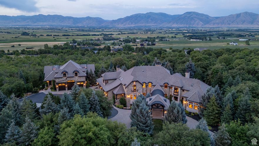 Discover luxury mountain living in this 16,000 sq ft estate on 26 private acres at the foot of Utah's Wellsville Mountains. This gated trophy home features an indoor pool, racquetball court, deluxe kitchen, and artisan wood and stone finishes. Designed for privacy and elegance, the property boasts smart home technology and panoramic views. Enjoy four-season recreation-snowmobiling, skiing, hiking, fishing, and hunting in the beautiful Cache Valley and surrounding mountains.  Minutes from Utah State University, 2 LDS temples, and close to SLC's cultural and professional sports scenes, international airport, Park City's world-renowned skiing, Jackson Hole, Yellowstone, and Utah's Mighty 5 National Parks which includes Zions and Arches.  A day's drive to the Pacific Coast, and Las Vegas.  This home is central to all that the western part of the USA has to offer.  A truly one-of-a-kind home and legacy opportunity.