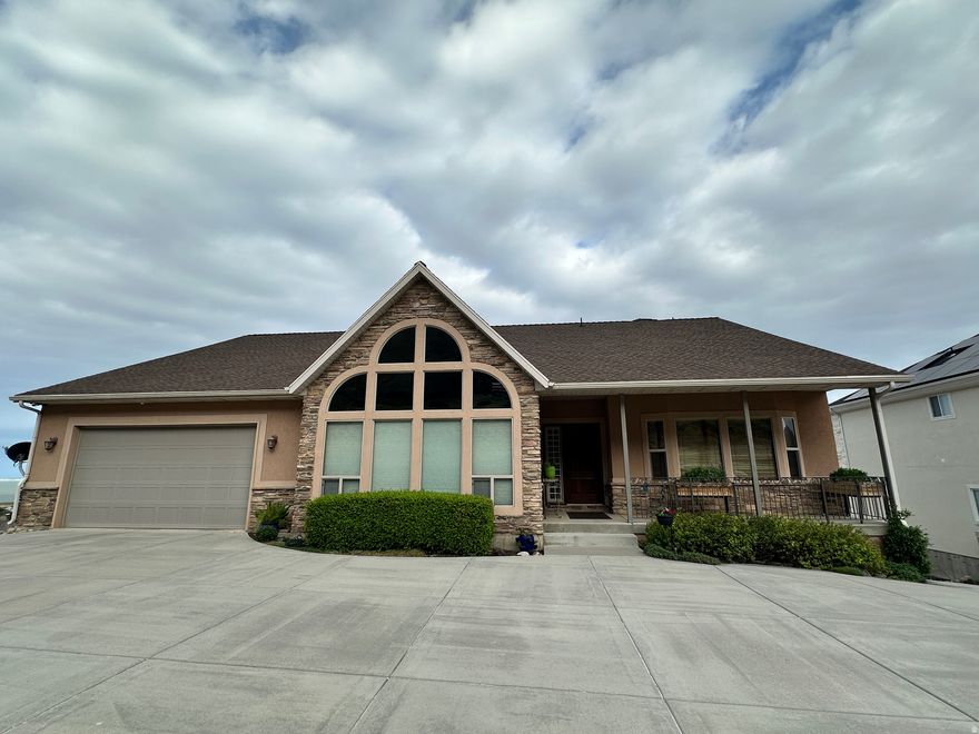 Spectacular views of Willard Bay and the mountains offer sunrises and sunsets that are unforgettable.  This beautifully finished home features granite counters, elegant glass fireplaces, designer lighting, and luxurious tile throughout.  The primary suite has a walkout to the deck, separate tub, shower and double vanity.  Double garage enters to the main level.  From the lower level, the massive 14' tall and 43' length RV garage is heated, easily fits a 40' motorhome, boat, trucks and is ideal for all your toys.  The basement has it's own full kitchen and laundry making it great for a mother-in-law retreat or can possibly be an accessory dwelling unit (ADU).