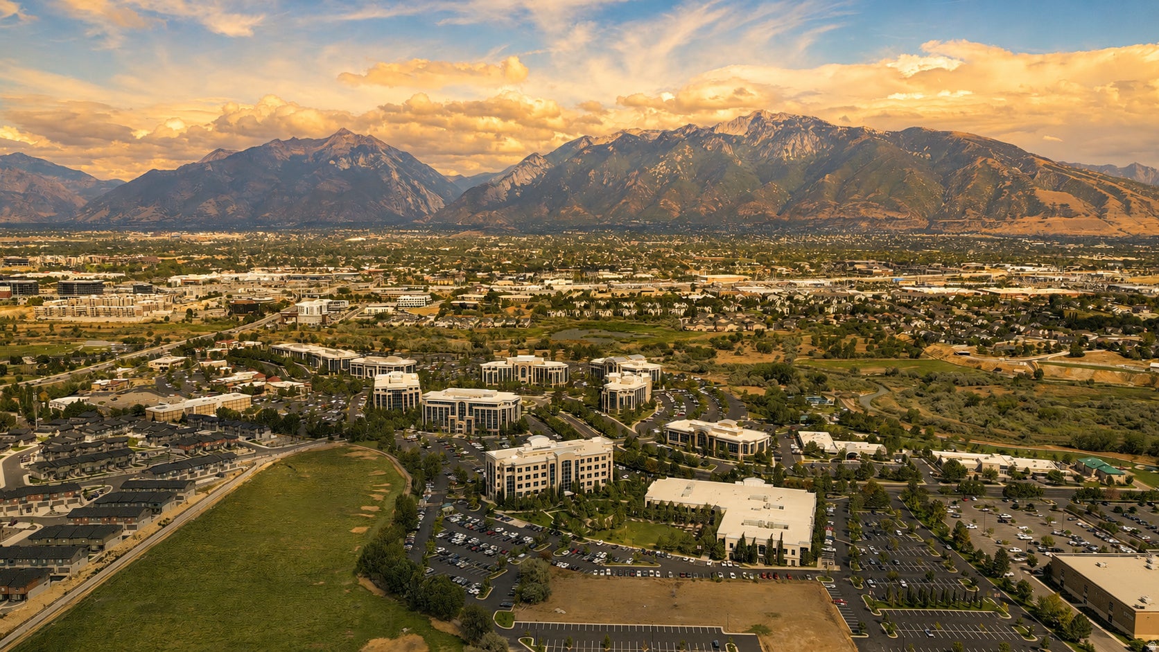 Expansive mountain backdrop with a developed urban landscape, featuring commercial buildings and residential areas
