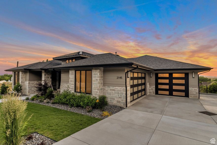 This fabulous rambler was Symphony Homes' 2023 Parade home, so there are TONS of upgrades and features throughout, including a LEGIT theater room under the suspended slab and another finished workshop area with epoxy floor and garage door to the backyard. Fully landscaped and fully fenced, nearly 1/2 acre lot, complete with a sports court and fire pit patio area. True walkout basement, and spiral staircase up to the large covered deck from main level boasting an incredible view of the lake and Utah's sunsets! Main level is the perfect floor plan and has extra high ceilings and 8' doors. Primary suite is huge, with an eye-catching beam ceiling, and a bathroom suite and custom closet to adore! Large dining nook surrounded by windows. Kitchen has a butler's pantry and commercial grade appliances. 3rd stall of the finished garage is 32' deep and there is a no-step entry from garage to mud room, and a utility sink. Stunning modern appeal inside and out! Designers hit it out of the park with this beauty! Click 'Tour 2' for 3D tour!