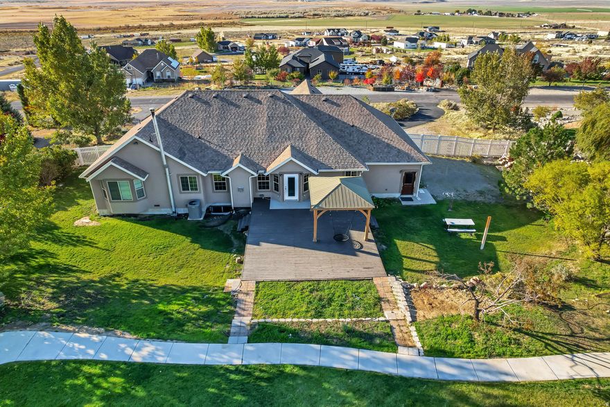 Gorgeous 6-Bedroom Home on 2 Acres - Fully Upgraded with Exceptional Outdoor Amenities  Discover the perfect blend of luxury, functionality, and space in this beautifully designed 6-bedroom, 3.5-bathroom home set on 2 acres of landscaped grounds in the desirable South Rim neighborhood of Tooele County, just outside Stockton City.  This meticulously maintained property offers high-end finishes, thoughtful design, and versatile living options throughout. The spacious kitchen is a chef's dream-featuring dual sinks, premium upgrades, and an expansive walk-in butler's pantry with counters, drawers, and abundant storage. A second kitchen adds flexibility for entertaining, multi-generational living, or a potential mother-in-law setup.  The finished basement includes a separate entrance and can easily function as a self-contained apartment. Inside, soaring vaulted ceilings, bright open spaces, and a bonus room above the garage create an inviting atmosphere perfect for family living or hosting guests. The 3-car garage includes an extra-deep bay and convenient basement access. Fiber optic internet ensures fast, reliable connectivity-ideal for remote work or home-based businesses.  Step outside to enjoy a stunning outdoor oasis. The fully fenced backyard is designed for recreation and relaxation, featuring a spacious deck with gazebo, a 10-foot fenced sports court with oversized basketball hoop, a 330-foot concrete walking loop, an in-ground trampoline, and a 12x12 sandbox. Gardening enthusiasts will appreciate multiple raised garden beds, mature perennials, and fruit trees producing peaches, apples, and pears. Mature shade trees, lush landscaping, and animal rights for horses or livestock enhance the property's country charm.  An undeveloped portion of the acreage offers exciting possibilities for future expansion, additional outbuildings, or pasture space-ready to be customized to your vision. Enjoy panoramic mountain views, a friendly community atmosphere, and convenient access to local parks, ATV/horse trails, nearby services, and the city of Tooele for shopping and amenities.  Located just 4560 minutes from Salt Lake City, this property offers the rare combination of tranquility, space, and accessibility. A must-see for discerning buyers seeking quality craftsmanship, flexibility, and an unparalleled lifestyle.  Square footage figures are provided as a courtesy estimate and were obtained from the seller. Buyer is advised to obtain an independent measurement.