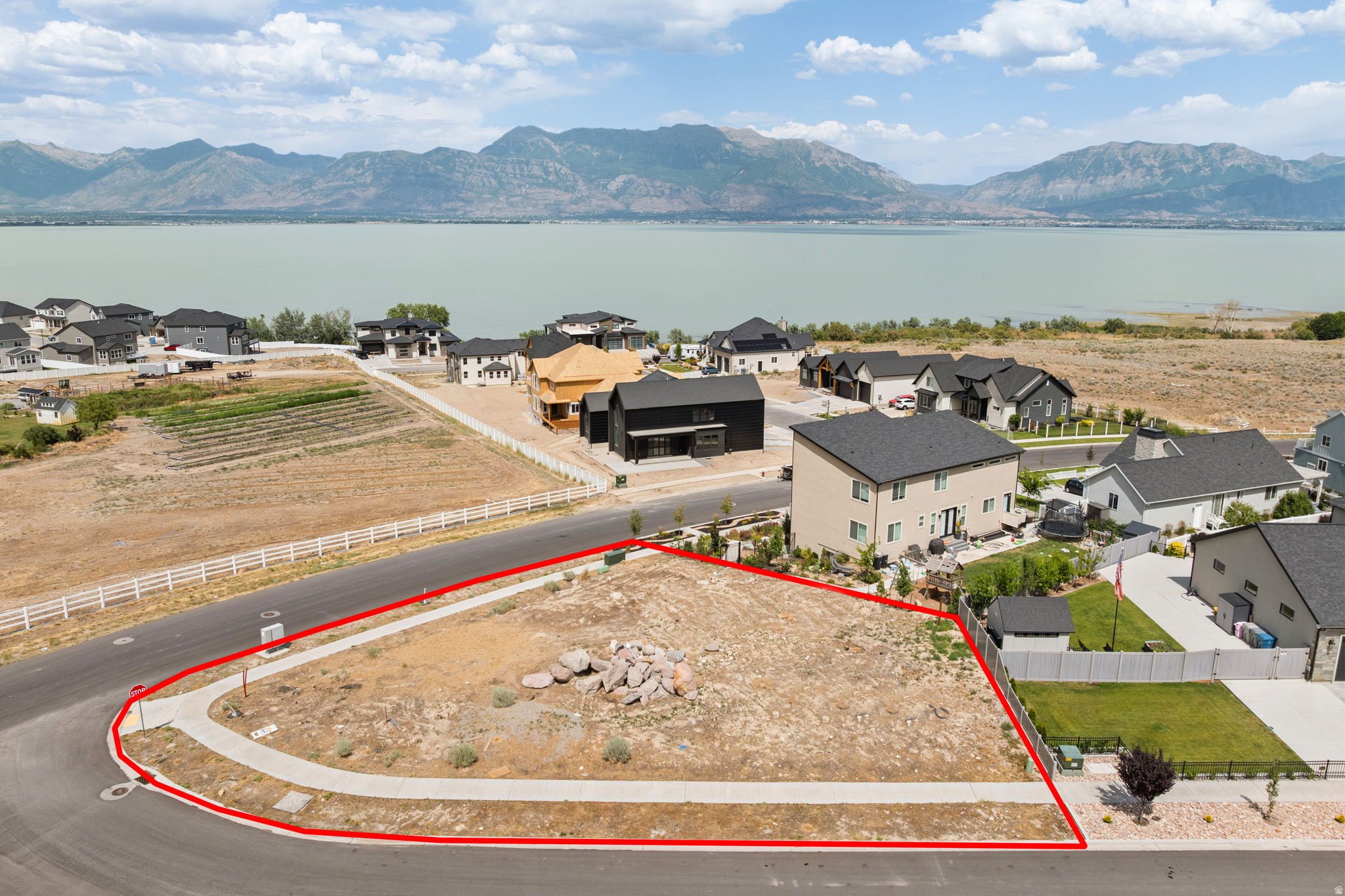 Expansive corner lot featuring a paved sidewalk and street frontage
