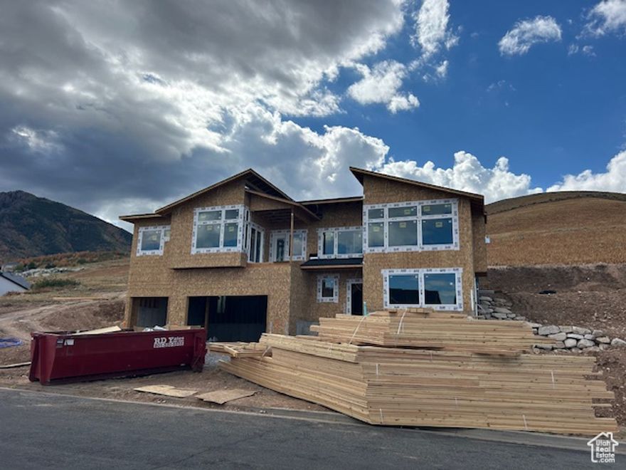 Mountain-Modern styled home dramatically set high up on the hillside above the city - true "East-Bench" living at an amazing price!  A multitude of generously-sized windows direct the occupants gaze to the surrounding beauty of nature and the city.  Spacious rooms, modern iron railings, white cabinetry and granite countertops adorn the living space.  Enjoy sitting on the covered front deck overlooking the view or relax on the rear covered patio.  Large Primary Bedroom with vaulted ceilings, large walk-in closet and separate tub/shower and two sinks in the adjacent bathroom.  4th bedroom can easily be an office.  The lower level features a full one-bedroom apartment (sans kitchen cabinetry) with separate entrance!  Come envision your life in this amazing home!  Taxes are approximate as they have never been assessed on built home on the property.