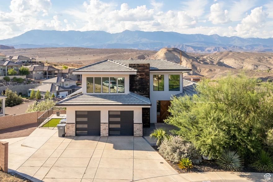 Nestled in Hurricane valley with sweeping views of Pine Valley Mountain and the Greater Zion Region, this home blends modern comfort, thoughtful design, and plenty of space for everyone. With over $200k in upgrades, this home leaves no stone unturn. The main level showcases gorgeous wood floors, a solid wood front door, and a striking entry with herringbone detail and modern chandelier. The living room highlights the views with oversized windows, while the kitchen features wood cabinetry, stone backsplash, a walk-in pantry, white quartzite counters, and premium appliances including an LG fridge and Frigidaire oven. A cozy casita with its own entrance, mini split, kitchenette (mini fridge and microwave), and bathroom offers flexible guest space. The primary suite is a true retreat with its own washer and dryer, soaking tub, rain head shower, closet built-in drawers, and direct access to the main laundry. Additional touches include a guest bath with a Onyx stone sink, wood-capped stairs, built-in cabinetry, and large windows throughout for natural light. Entertainment and functionality shine in the walk-out basement with a full kitchen, laundry, and a movie projector with screen, plus mini splits for comfort. The lower level is the perfect Accessory Dwelling Unit (ADU) with tons of investment potential. You have full kitchen, 2ndliving room, 2 bedrooms, and 2 bathrooms. Upstairs you'll find a spacious loft, while the home also boasts epoxy-finished garage floors, solar panels, and smart storage solutions. Outdoor living is easily accessed with two covered patios, a hot tub, deck with stairs, garden boxes, in-ground trampoline, fire pit, and extra parking on the side. Every detail-from the wood finishes to the modern fixtures-makes this home both welcoming and impressive.  The home is a short drive to the sheer massive cliff walls of Zion National Park, the hoodoos of Bryce Canyon National park, or the North Rim of The Grand Canyon. There is no place like it. Enjoy nearby hiking, biking, and outdoor adventures or any of the 4 amazing large reservoirs and thousands of recreational public acres for the adventurous at heart. The region is also known for its internationally renowned golf courses that recently hosted the PGA tournament and will soon host the LPGA. Saint George is also the host for many events such as the Ironman, Red Bull Rampage, and the Saint George Marathon. A 5-minute golf cart ride from this home gets you to Green Spring Golf Course, host of the Huntsman Senior Games Golf Championships.  All information herein is deemed reliable but is not guaranteed. The buyer is responsible to verify all listing information, including square feet/acreage, to the buyer's own satisfaction.