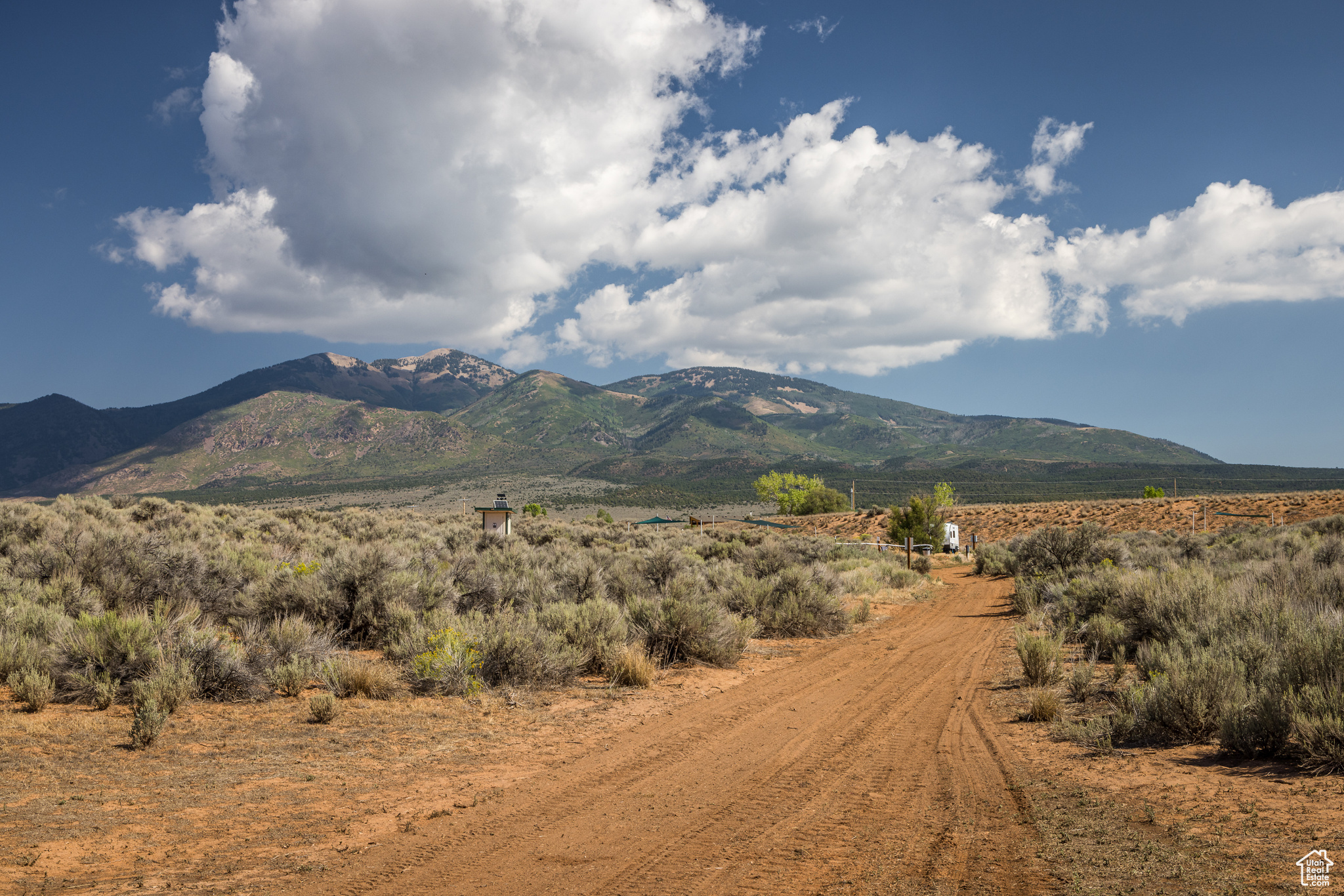 Bask in views of three mountain ranges from your campsite or custom home, the La Sal Mountains, the Abajo Mountains and the Henry Mountains. A dry pond bed and mature trees create an earth wall of privacy and protect your viewshed of the La Sal Mountains. There are many ways to enjoy this fully fenced 39-acre parcel. The gravel road from the gate leads to a campground with four established sites and a caretaker site that has rave reviews. Each site includes a fire pit, picnic table and shade arbors. There is also a pit toilet and trash receptacles. A sophisticated well house has 3200 watts of solar on the roof and there is currently enough power to expand to twenty sites. Seven acres of irrigated wildland grass encourage deer and other wildlife. The land is also subdividable, which creates even more options.