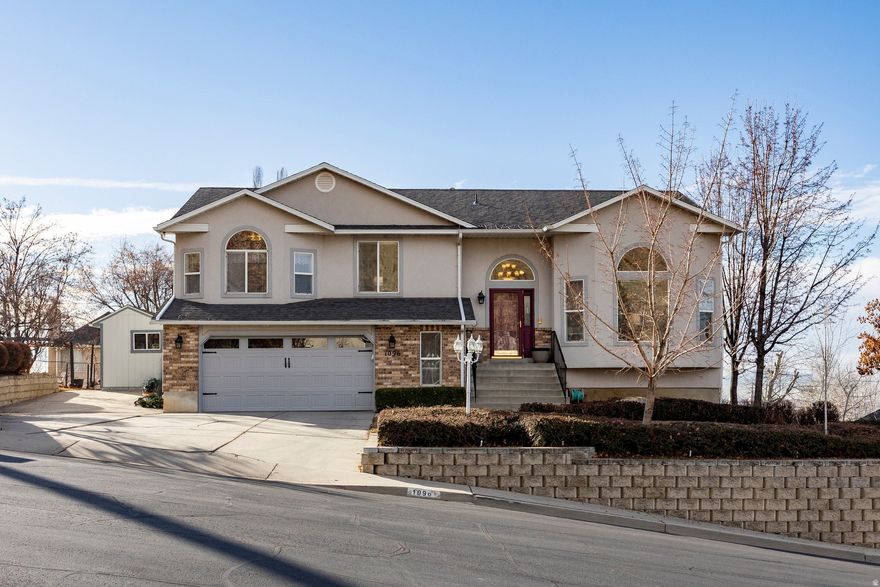 Beautiful home on the desirable East Bench of Lindon. Perched  high above the valley with breathtaking panoramic views. This meticulously maintained 5-bedroom, 3-bathroom home offers a spacious open floor plan designed for comfortable living and entertaining. Vaulted ceilings in the living room create an airy, light-filled space, while the generously sized bedrooms provide plenty of room for everyone. Enjoy the wonderful yard with ample space for gardening, outdoor activities, and relaxation. The charming patio draped with grapevines creates the perfect setting for outdoor dining and gatherings. An amazing deck off the family room - complete with a covered deck below - allows you to take full advantage of the incredible views year-round. The walkout basement adds flexibility and convenience, and the 2+ car garage includes extra width offering potential space for a workshop or additional storage. A rare opportunity to own a stunning home in an exceptional East Bench setting!