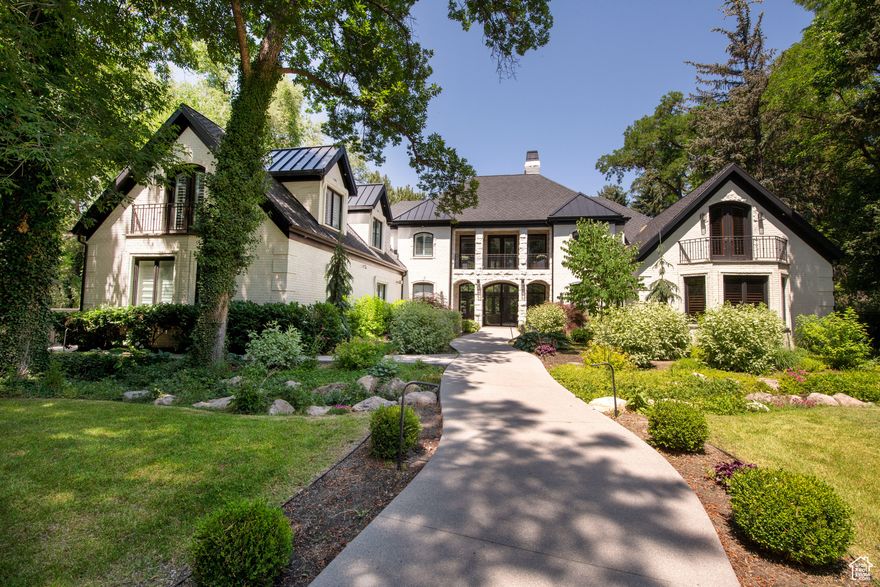 Moderne elegance with grand spaces lined in glass overlooking lush gardens and leisure outdoor living areas. Totally redone recently with pizazz! Gated and secure with a circle drive approach to the stately front entrance court.  This home is truly designed for entertaining. The open spaces flow together inside and flow from the inside right out to verandas, patios, pool, spa, outdoor kitchenette, and a charming stream and waterfall feature. Everything is new from the rich wood floors and classy modern fireplaces to the stunning gourmet kitchen and beautiful baths. The "great room" showcases the ultra-modern kitchen, family and dining space. Formal living/dining flows off the entry with double height drama! The library is on the main with vaults, rich classy built-ins and a separate work room. The primary retreat on the main is vaulted, spacious, and firelit with views out over the estate. The true luxury spa bath has opulent fixtures and finishes plus a soak tub and steam shower. Upstairs, a lofted walkway overlooks it all while connecting two distinct bedroom wings each with two ensuites, a second laundry and several sitting areas. The lower level has the fun spots with a zippy theatre with rock fireplace, wet bar, plus a wide-open rec room that flows out to the grounds and pool! Two more ensuites are here plus a powder room. There is storage galore. The side load four car garage is heated. The curb appeal and interior dcor are crisp and beautiful! This lot is almost an acre with big trees and privacy! Best of all, the location and surroundings are as good as it gets! Generator is excluded.