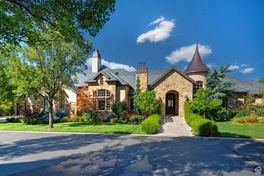 Discover the elegance of this stunning European-style home located in one of Holladay's prestigious gated communities. This architectural masterpiece features a spacious five-car garage, an elevator for easy access, and an entryway that promotes effortless living. Inside, two exquisite master suites are connected by a hallway adorned with crema Marfil marble, while the grand two-story family room with stunning beams and expansive windows seamlessly connects to a luxurious kitchen. The lower level offers three additional bedroom suites, a sauna, a shower, and a dedicated theater room for optimal entertainment. Step outside to a charming covered deck overlooking a lush garden area complete with mature trees, colorful shrubs, and tranquil waterfalls-perfect for relaxation or entertaining guests. With its updated, move-in ready condition and prime location just minutes from the 215 freeway, downtown, and ski resorts, this captivating residence is a true must-see! Square footage is provided as a courtesy only. Buyer is advised to obtain an independent measurement and to verify all information.