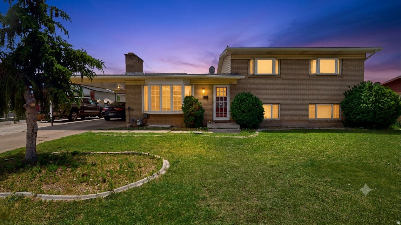 Brick exterior with multiple windows, a prominent bay window, and an attached carport