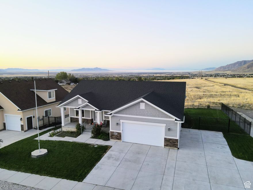 Views for days!  Mountain views from the front and water views from the back!  If you're tired of the cookie cutter subdivision houses, come and see this beautiful home in the desirable Vista Linda development.  Enjoy sunsets from your private deck that looks out over the Salt Flats and the Great Salt Lake!  The basement has a walk out entrance , two bedrooms, a full bath, kitchenette and laundry hook-ups making it a great mother in law suite or a possible ADU.  There is ample parking for extra cars, a boat or a RV to the east of the attached garage.  The back yard is fully fenced and the entire property is landscaped and has an automatic sprinkler system.