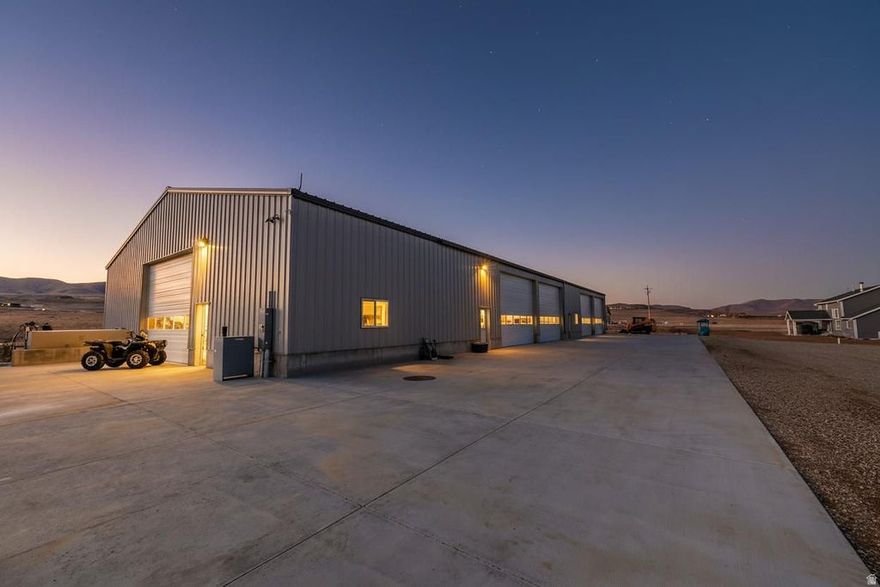 You have to see it to believe it a 1.5 acre building lot in Thatcher Utah that includes an 8400 sq ft  3 bay industrial shop with incredible potential for a Barndominium a spacious office or even expansive storage This is more than a shop it's a refined workspace equipped with top of the line features. Bay one offers 4800sq ft designed for a high end cabinet fabrication operation  complete with 480 amps of 3 phase power ,overhead track systems for internet communication and air lines, a screw compressor with a reserve tank and vacuum systems throughout the work areas. Additionally, there is a plumbed bathroom, radiant heated floors and air conditioning. Bay two is 2400 sq ft and presents a flexible footprint perfect for a large office or living quarters It is tall enough for a second level and already includes a half bath with plumbing in place for a shower. A kitchenette is in and the furnace, plumbing and electrical are ready to go The remaining 1200 sq ft  bay is currently a wash bay but could easily be repurposed for storage or other uses The front portion of the lot has been leveled to a smooth surface that originally was a hockey rink or would most likely be used as the area to build a home. This property harmonizes strong industrial capability with flexible living and office potential. Adjacent to  the highway and I-15 freeway access it's a  wonderful opportunity for manufacturers fabricators or investors who want a space they can tailor to evolving needs. *Parcel  is zoned M-G General Industrial  with the front half undergoing rezoning to residential a process that will be completed before closing if needed *Some equipment remains on the site but not everything is included and there is the option to purchase additional equipment separately  *All information herein is deemed reliable but is not guaranteed. Buyer is responsible to verify all listing information, including square feet/acreage, to buyer's own satisfaction.