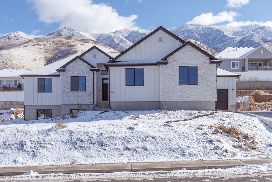Welcome to this stunning custom home nestled in the hills of Santaquin, Utah, offering breathtaking mountain views from the backyard and sweeping valley views from the front porch. This is a home you truly don't want to miss.  Built as a full custom residence, the quality and craftsmanship are evident throughout-from the moment you arrive to the details you'll see and feel inside. The striking curb appeal draws you in, and stepping through the front door reveals an open, vaulted family room that is both inviting and impressive.  The home features beautiful vaulted ceilings that enhance the spacious, open feel, along with sleek black exterior windows that perfectly complement the modern design.  Complete with a fully finished 3-bedroom basement ADU, this property offers incredible versatility. The ADU includes its own separate garage and boasts a bright, open layout that mirrors the main level, carrying consistent design themes throughout the entire home-ideal for rental income, multigenerational living, or guest space.  With a total of 6 bedrooms and 4.5 bathrooms, this home offers ample space for comfortable living, entertaining, and flexibility.   A rare opportunity to own a thoughtfully designed, high-quality home with unbeatable views in one of Santaquin's most desirable hillside locations.