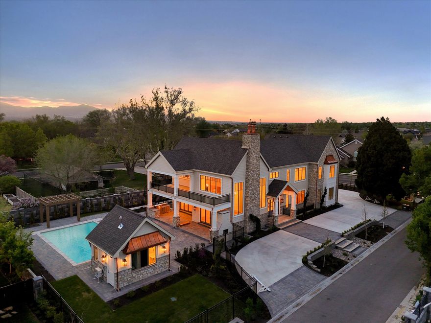 Set within the prestigious Viking Court subdivision, this newly constructed residence by the highly regarded Silverhawk offers a rare expression of modern luxury-where scale, craftsmanship, and livability come together in a way that feels both commanding and considered. From the moment you enter, the home reveals itself with intention. Soaring 10'20' ceilings and expansive light-filled volumes create an immediate sense of scale, while wide-plank White Oak flooring and custom White Oak beam detailing ground the architecture in warmth and texture. Every finish feels deliberate-elevated, but never overstated. At the center of the home, the kitchen acts as both anchor and gathering point. Custom inset cabinetry, striking quartzite surfaces, and seamless connectivity to the surrounding living and dining spaces create a natural rhythm for both everyday living and elevated entertaining-equally suited for quiet mornings or full-scale gatherings. The main-level primary suite is its own private retreat. Direct access to a covered patio extends the space outward, while the spa-inspired ensuite introduces a more refined pace of living-an oversized walk-in shower, freestanding soaking tub, heated tile floors, and a beautifully built-out closet with integrated laundry, designed with both function and ease in mind. Upstairs, four generously sized ensuite bedrooms offer privacy without compromise-each thoughtfully designed with custom closets and an emphasis on comfort, proportion, and light. The lower level continues the experience at a different scale-bright, open, and intentionally flexible. Light wells bring in natural illumination, creating a space designed for both entertainment and adaptability, whether envisioned as a theater, golf simulator, or expansive gathering space. And then there is the connection to the outdoors-where this home fully opens up. A fully retractable pocket door dissolves the boundary between inside and out, leading to an extraordinary covered paver patio that spans the entire south side of the home. This resort-inspired space is fully realized, with dedicated dining and lounge areas, a complete outdoor kitchen, and direct access to a stunning pool with integrated spa and a private pool house-creating a true extension of the home rather than a separate experience. The grounds are designed to match the architecture in both scale and intention-professionally landscaped, fully fenced, and framed by a paver driveway and grand entry sequence. An oversized 6 car garage completes the property, offering exceptional space for vehicles, storage, and lifestyle flexibility. This is a home that doesn't simply offer luxury-it defines it. A statement residence where design, function, and experience align in one of Draper's most sought-after settings.