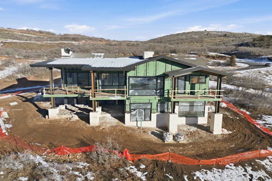 Welcome to Halo Crest. Approach a grand covered front patio leading to a full-glass front door, immediately setting the tone for the quality, scale, and sophistication found within. Set on one of the largest and most coveted homesites in the Golden Eagle neighborhood, this exceptional new construction residence represents a masterful blend of inspired architecture, elevated wellness living, and effortless indoor-outdoor design. Thoughtfully designed by Budingen Architecture and built by Jorgenson Builders, the home is defined by expansive walls of glass, grand entertaining spaces, and private bedroom retreats-all oriented to capture breathtaking views and abundant natural light. The residence offers five bedrooms, seven bathrooms, a dedicated office, a spacious mudroom, and an oversized three-car garage, providing both luxury and livability at every turn. At the heart of the home, dramatic living and dining spaces unfold with architectural intention-the dining room framed by dual glass walls, and the great room featuring a moving glass wall that dissolves into nearly 1,000 square feet of deck and patio space, creating a seamless extension of the living area for year-round entertaining. A private wellness center elevates the home to resort-level living, complete with a workout area, sauna, cold plunge, and  bathroom-designed for restoration and daily balance.  Halo Crest is a rare opportunity to own a newly built architectural statement on an oversized lot in Golden Eagle-where refined design, privacy, and views come together in perfect harmony.