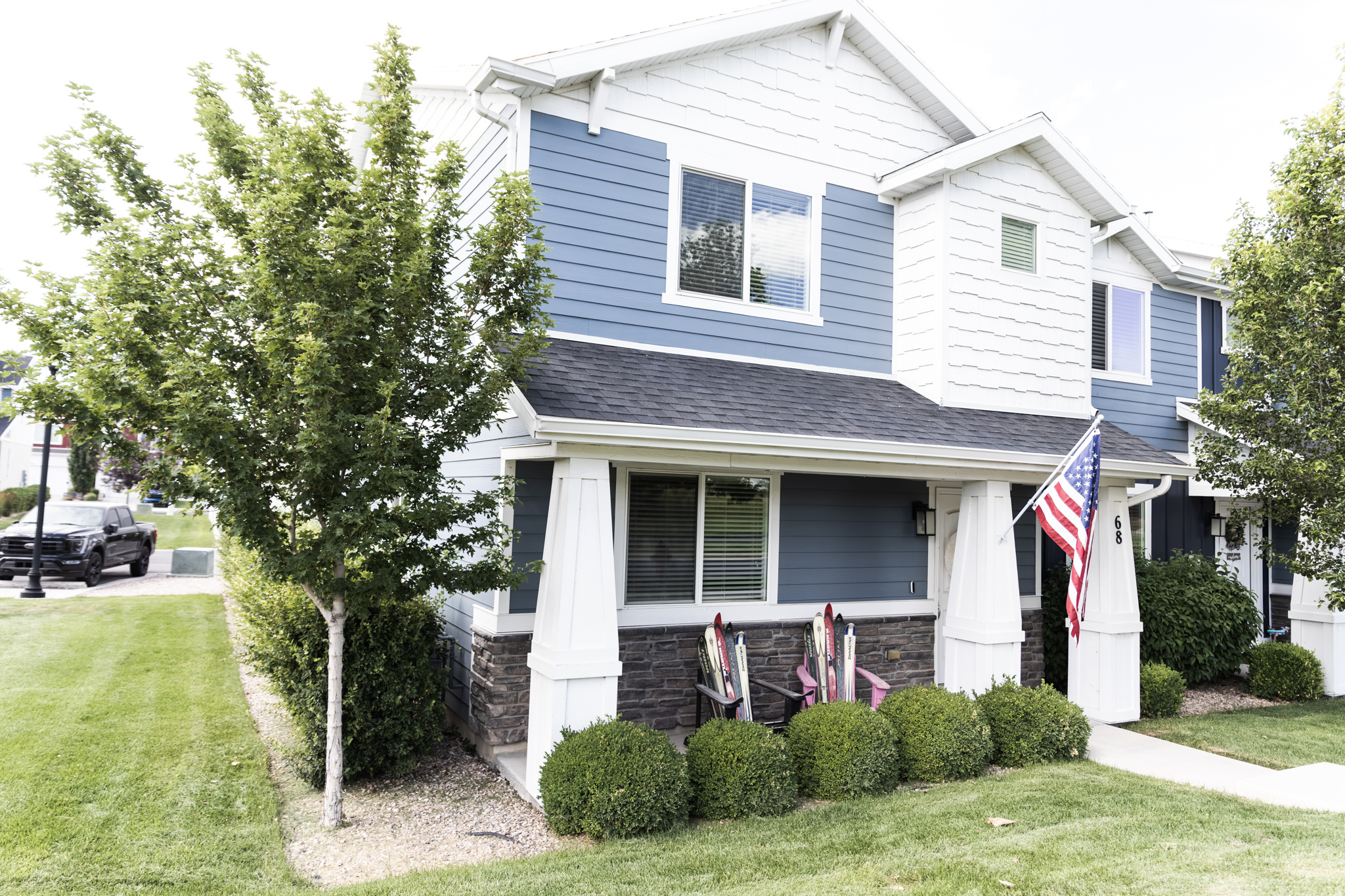 Exterior featuring blue siding, white trim, and a covered entry with stone accents