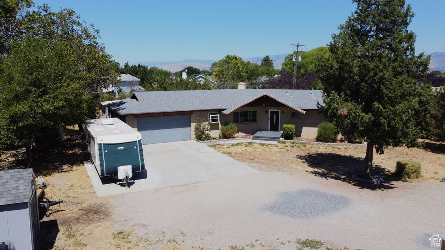 Unique home on a huge 0.64 acre lot!  POSSIBLE DEVELOPMENT POTENTIAL - city planning/zoning has it in the "neighborhood commercial" area of their master plan, and the property is perfectly situated on 5400 S for commercial use with high traffic count and visibility.  Otherwise, make this large 3,100 SF home your new residence!  The fully-fenced yard has plenty of space for activities.  Large 2-car garage with pull through door, plus RV parking with 30amp electrical hookup and RV dump station.  Tons of parking space for your toys.  The 1960's style and flow of the home is alive and well, yet several updates throughout have made it more modern and comfortable.  Some of the updates include all new light fixtures throughout the main level, all new windows and doors installed in 2016, 4 yr old furnace, and the roof is only 9 yrs old.  The basement has great potential to become a basement apartment as the entrance separate coming in through the garage.  There is also a kitchenette downstairs, space to add laundry, and a partially finished bathroom space.  Whether you're looking to develop the property, or enjoy as a residential home on a big lot, this is a great opportunity - come see for yourself today!