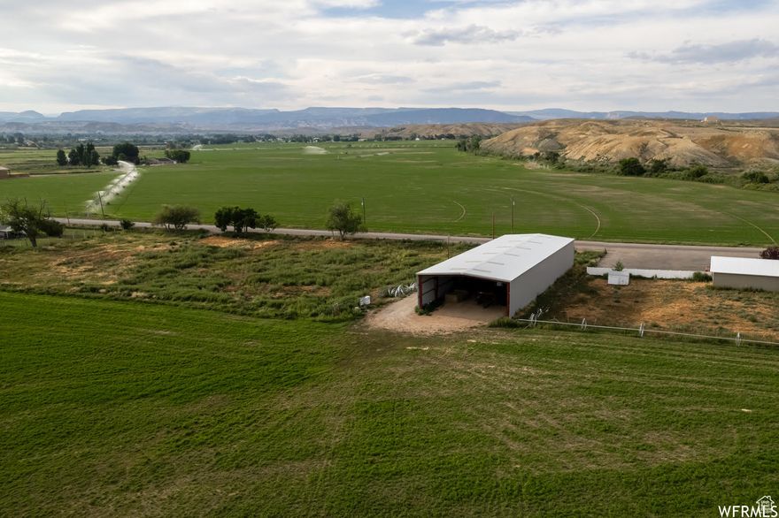 This fully fenced acreage would be prime horse pasture property, farming ground for anyone wishing to raise crops or an incredible place to escape and build your dream home.  Acreage includes large frontage for endless options.  Power already stubbed to property.  Includes power pivot irrigation water line.  Includes one irrigation wheel line .Includes well/spring water options.  Well Certificates 45-3503, 45-4408, Spring Flow Certificate 45-2022, 4.12 Shares of Rockpoint and 17.5 Shares Rockpoint S Stock. Culinary Water hookup on property.