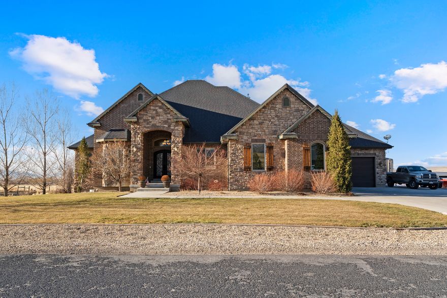 Stunning custom home tucked away on a quiet cul-de-sac in East Erda, set on over 2.5 acres with breathtaking views. This property offers a thoughtfully designed custom floor plan filled with high-end finishes, including plantation shutters, 10-foot ceilings, tray and coffered ceilings upstairs, and a striking iron front door that makes a grand first impression.  The primary suite is designed for comfort and convenience, featuring a private entrance into the laundry area with washer and gas dryer right off the walk-in closet. T  The spacious walk-out basement boasts 9-foot ceilings and incredible flexibility for entertaining, relaxing, or multi-generational living. Complete with a kitchenette, separate laundry (washer and electric dryer), and an outlet ready for a future hot tub on the patio. A private entrance through the garage adds even more versatility.  Step outside from the main level onto the covered patio - perfect for year-round entertaining while taking in the sweeping scenery. A gas line is already plumbed for outdoor cooking or fire features. The beautifully landscaped yard includes a cozy fire pit area and plenty of room to bring your animals and toys. Equestrian-ready amenities include a horse shed, covered hay storage, and a frost-free water spigot in the pasture.  Car enthusiasts and adventurers will love the impressive garage with abundant space for vehicles, toys, and storage, plus a separate 220-amp RV hookup on the side of the garage.  Additional highlights include two furnaces for efficient climate control (upstairs and downstairs). Water right 15-5437 with 1.59 acre feet of water included.  Square footage figures are provided as a courtesy estimate only and were obtained from county records.  Buyer is advised to obtain an independent measurement.