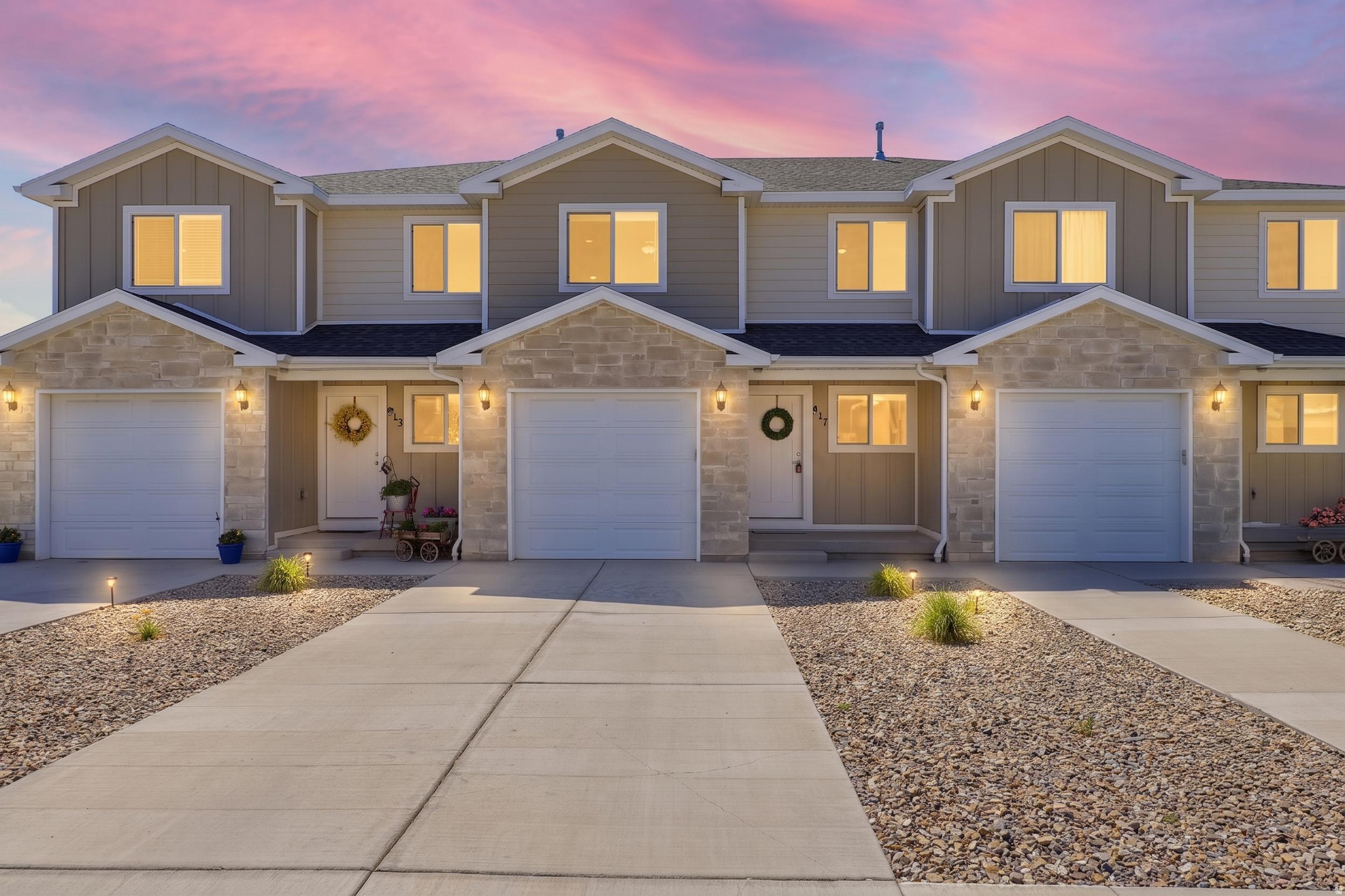 Modern townhome-style residences featuring light-colored siding and stone facade accents