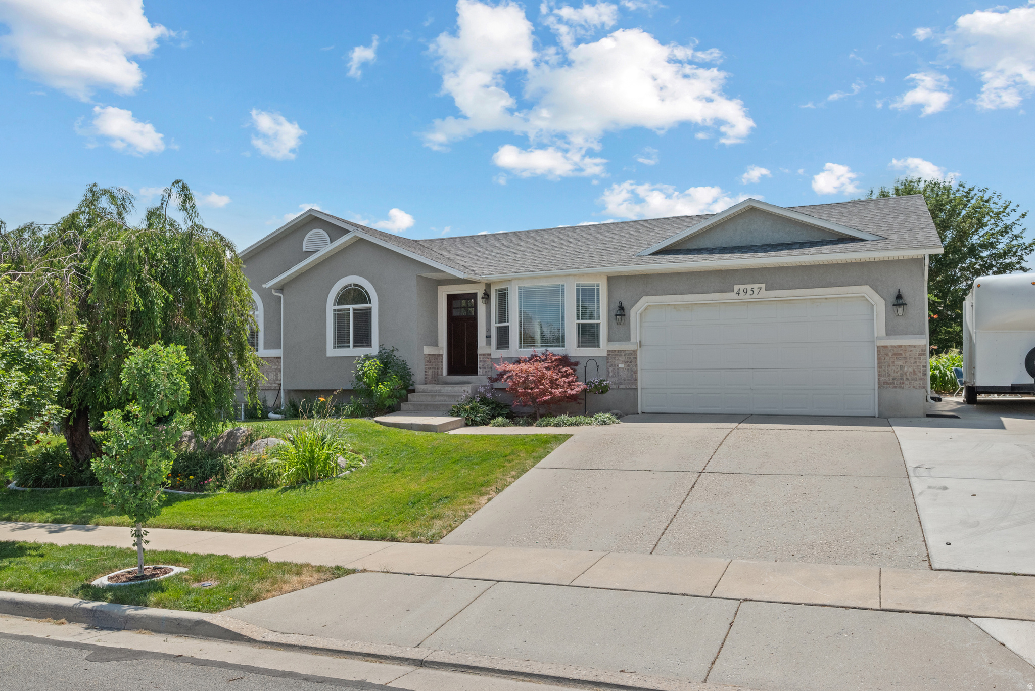 Stucco exterior with stone accents and an attached two-car garage