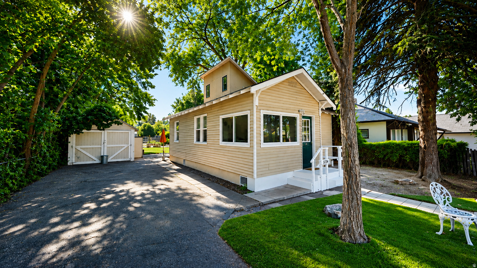 Single-story residence featuring light-colored siding, a dark green entry door, and white window trim