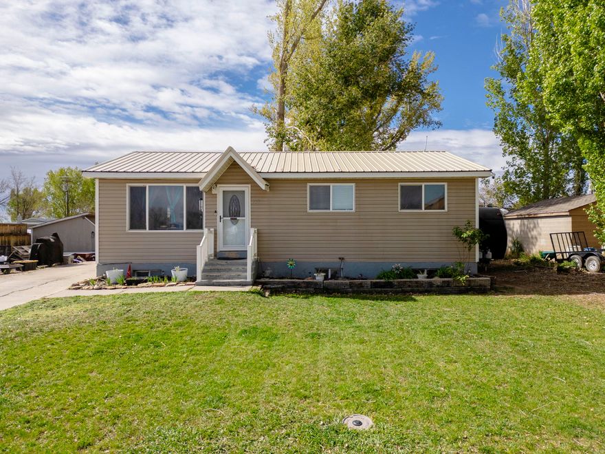Well-maintained and ideally located, this spacious home sits directly across from East Elementary School, offering convenience and a strong sense of community. With 6 bedrooms and a bathroom on every level, the layout is designed to accommodate a variety of living needs-perfect for larger households, guests, or flexible use of space. The main level features an open kitchen that flows seamlessly into the front living area, highlighted by an island bar that creates a functional and inviting gathering space. Recent updates add value and peace of mind, including a ** newer metal roof **, new kitchen sink, new downstairs toilet, brand-new carpet throughout the entire basement, as well as a newer water heater and dishwasher. Step outside and enjoy both relaxation and functionality. The backyard provides space to play, entertain, or unwind, while the front yard offers a welcoming setting to sit and relax. For those needing extra parking, the property includes a large graveled area with room for RVs, trailers, and additional toys a rare and highly desirable feature. Additional highlights include a storage shed for tools and equipment, and a sprinkler system in both the front and back yards, along with a drip system for the landscaping (systems have not been used by the current owner and condition is unknown). This property offers space, updates, and versatility in a location that's hard to beat don't miss the opportunity to make it yours. **Buyer is advised to obtain an independent measurement. Buyer/Buyers Agent to verify all info including sq. ft.