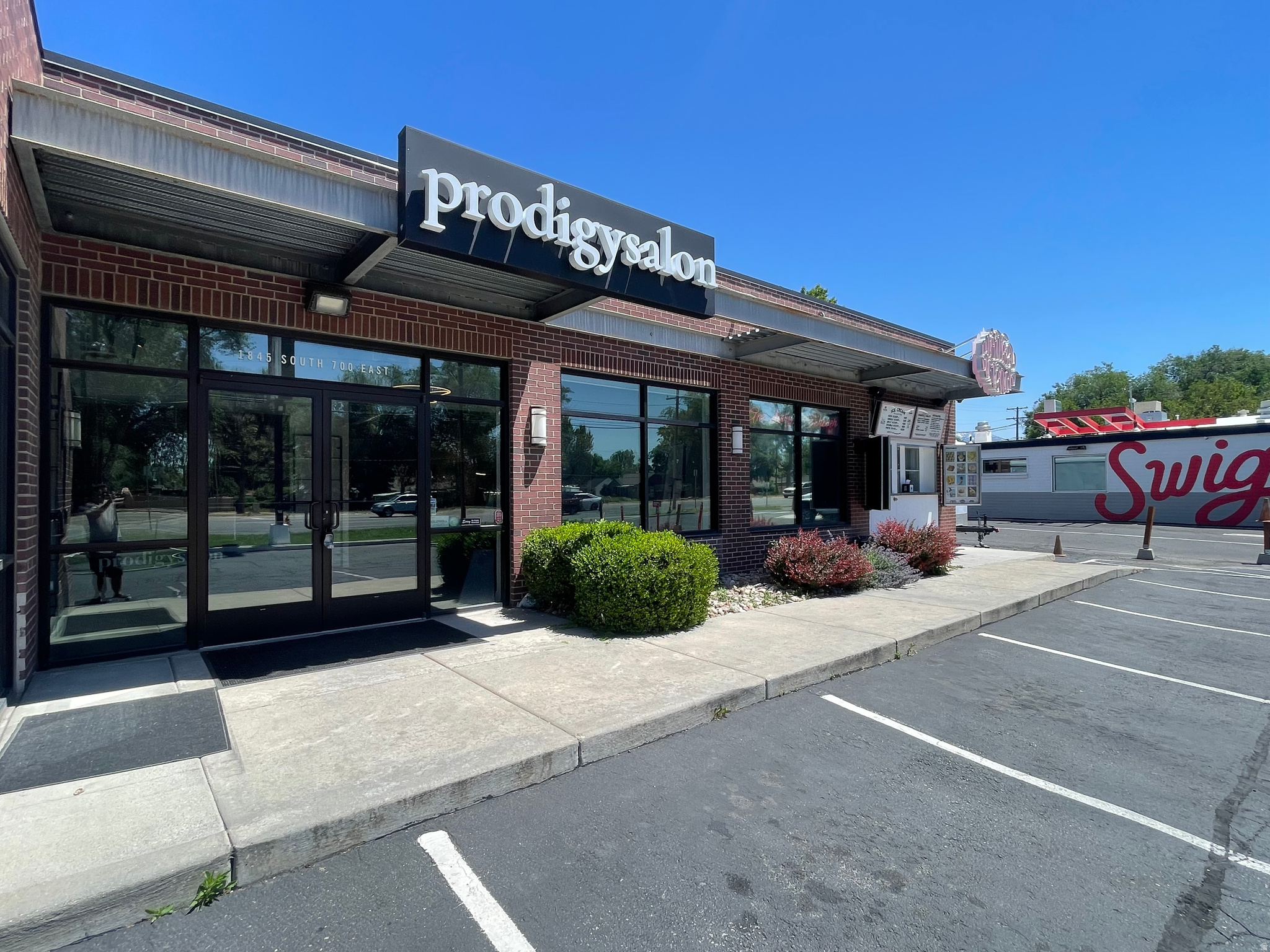 Commercial storefront featuring a brick facade with large display windows and a prominent awning