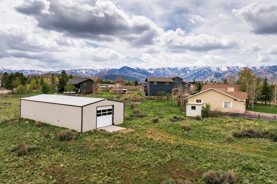You've been waiting for this - one of the largest, two-acre, flat, usable lots available in the Park City School District. This horse property in Highland Estates offers big mountain views and space to build something exceptional. The centerpiece is a 30'  60' (1,800 SF) insulated, steel-framed metal garage with 13-foot drive-through doors on either end, and full heating and air-conditioning. Purposefully built for serious use - from trailers and RVs, to a workshop, collector's showroom, artist studio, wellness gym, barn, or hobby farm - this building was made for whatever you've been envisioning. The development potential doesn't stop there. Per county regulations, there is space to add one more major accessory building up to 2,500 square feet (Conditional Use Permit and planning approval required), plus another additional minor accessory building up to 400 SF. The five bedroom home is a blank slate - a main-level bedroom, three upstairs bedrooms, and an additional bedroom and flex space downstairs - with a footprint to design exactly as you want it. Only 7 miles to Historic Old Town Park City and less than 2 miles to Kimball Junction, with direct I-80 access. Where deer and elk roam freely, and with minimal HOA restrictions, there's room to build your setup on your own terms.