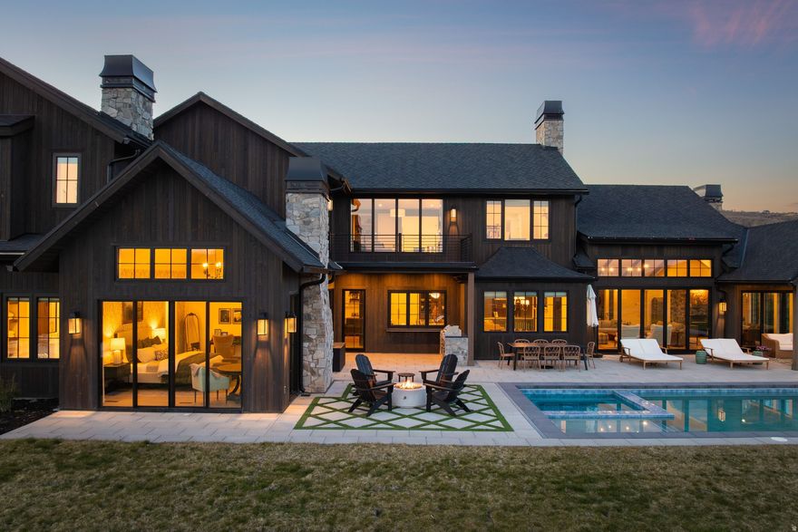 Set on 11.5 south-facing acres in The Preserve at Glenwild, this newly built Modern European Farmhouse captures sweeping Deer Valley and mountain views with refined design and seamless indoor-outdoor living. The 6,763 SF residence offers 5 bedrooms, 6 bathrooms, office, theatre room, workout room, and 4-car garage.  Vaulted ceilings with exposed wood beams and wide-plank wood flooring create a warm modern feel throughout. The chef's kitchen features a custom quartzite island, 6-burner range with griddle, paneled refrigerator and freezer, dual dishwashers, and walk-in butler's pantry. The primary bathroom features heated flooring for added comfort and luxury. Expansive living spaces open directly to outdoor entertaining areas with built-in grill, fire pit, pool, and hot tub.  The flat, usable acreage offers privacy, versatility, and future potential. One of the few properties in The Preserve with the ability to accommodate both a future guest house and horse barn. Located minutes from Glenwild Golf Club, Park City amenities, and world-class skiing.